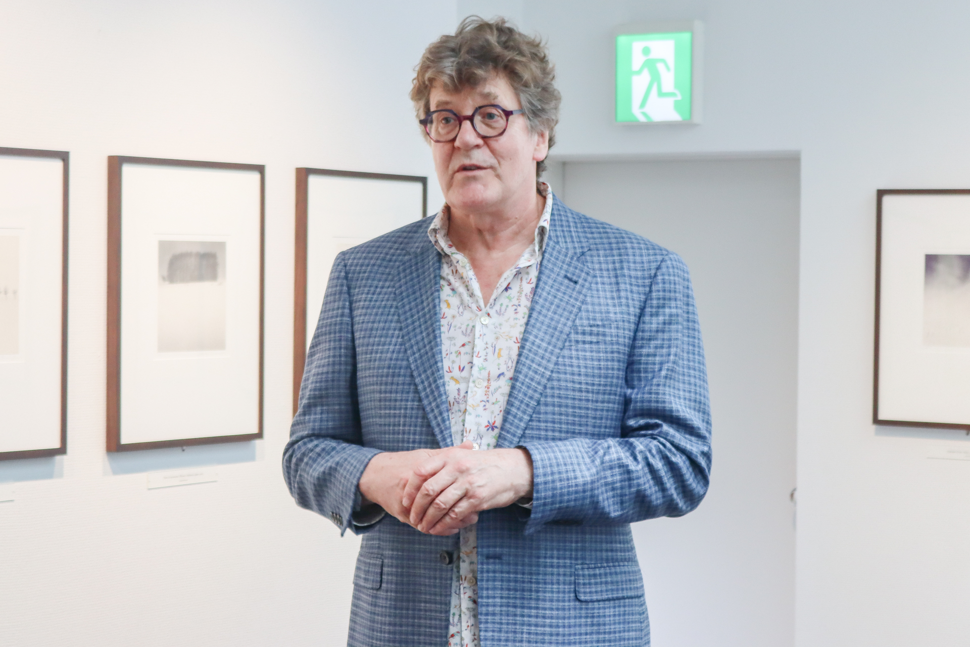 4月16日（火）、内覧会で自作を解説するマイケル・ケンナ氏。