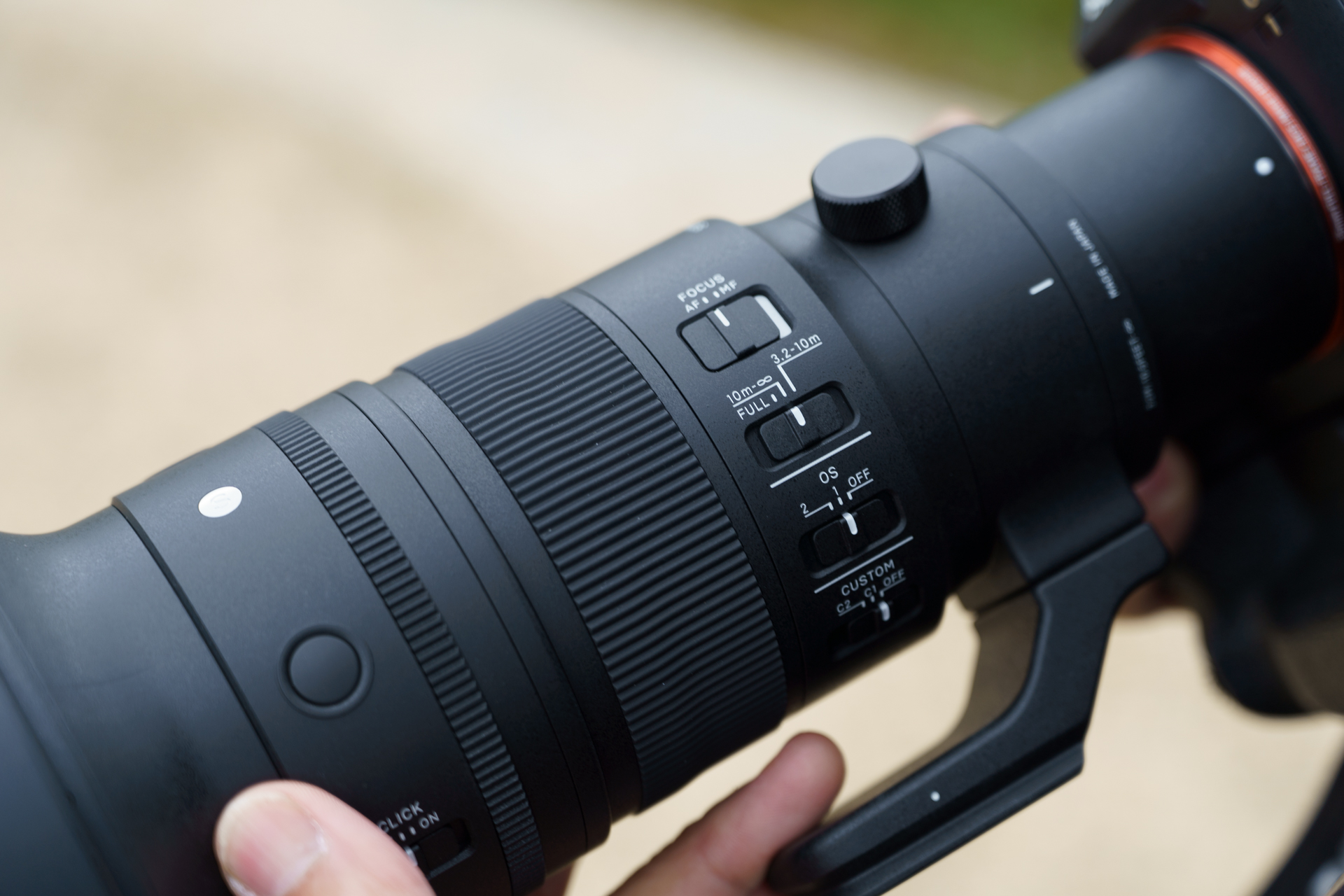 レンズ左側面のスイッチ類。上からAF/MF切替、フォーカスリミッター、OS（手ブレ補正）モード切替、カスタムモード切替