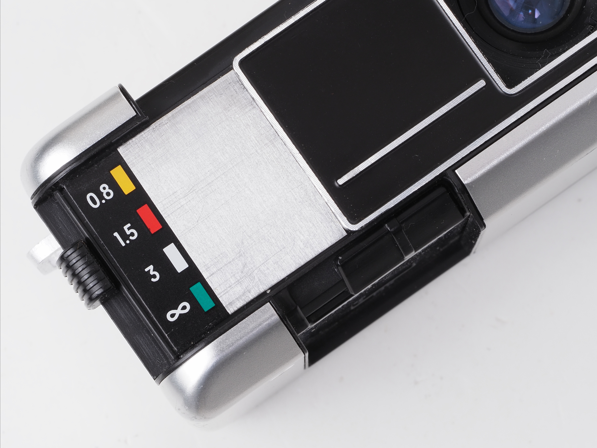 ゾーンフォーカス設定レバーです。0.8、1.5、3mにインフの4段階に設定できます。シャープな写真を得ようと考えるならマメに設定した方がいいでしょう