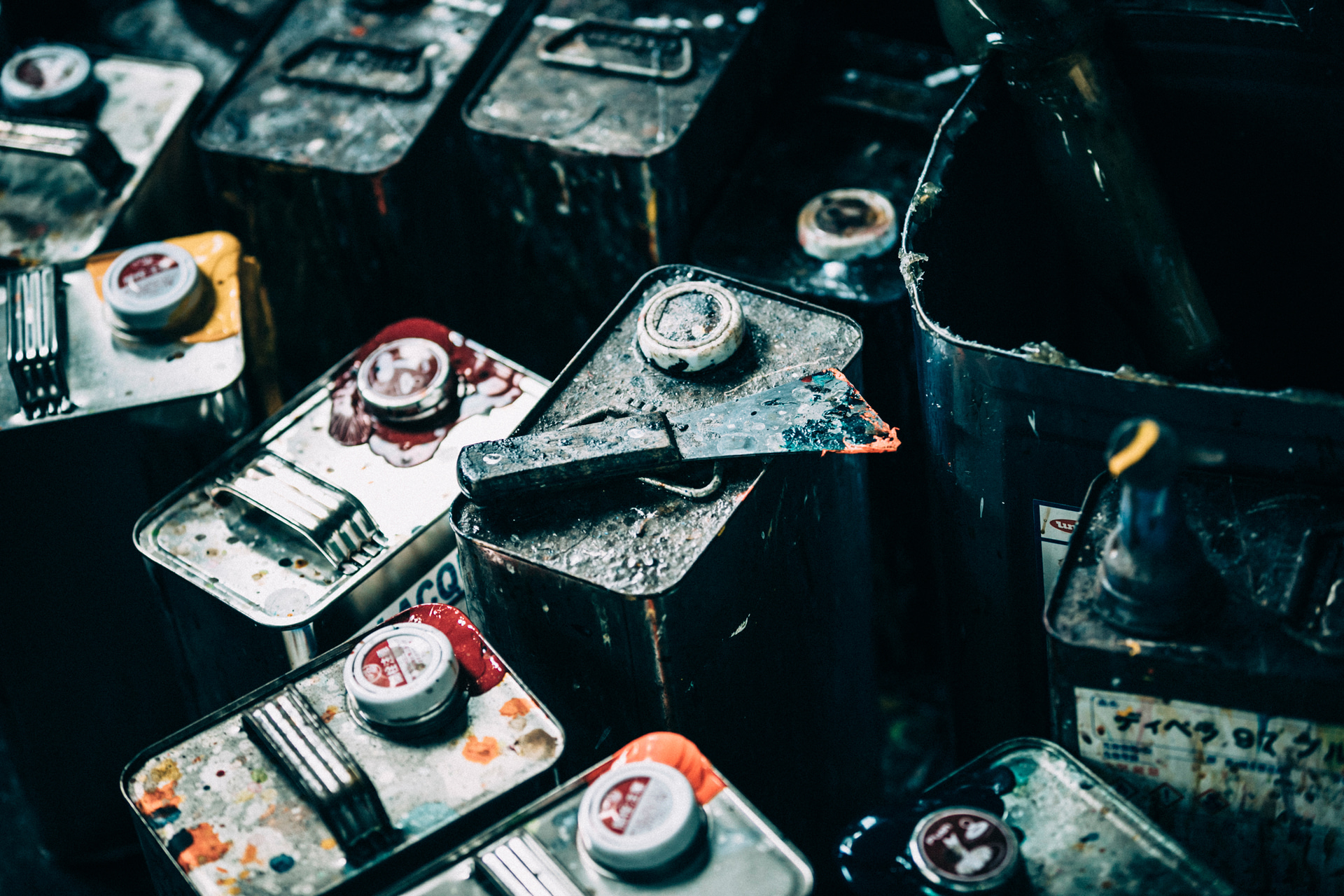 革の塗装に使う塗料の缶。職人が色を調合し、吹き付け作業を行う。革の良い匂いは実は革ではなく塗料の匂いだ。三脚に固定して、ピントを合わせた<br><span class="fnt-85">FUJIFILM X-H2／XF23mmF2 R WR／23mm（35mm相当）／マニュアル露出（F2.8、1/60秒）／ISO 400／WB：5,200K</span>