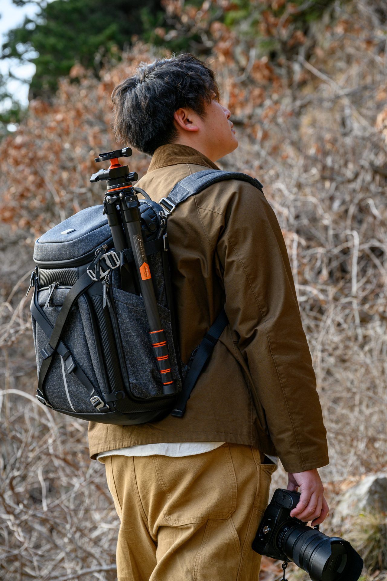 小さい三脚ならサイド部分に収納できる。正面のストラップを使うと大きな荷物や衣類を持ち運べる