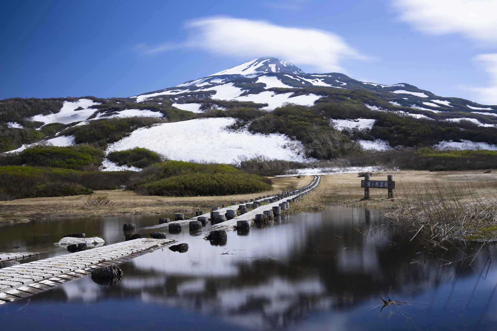 標高1,170mにある竜ヶ原湿原。まだ新緑の葉はほとんどなく、寒々しい景色だったが、天気も良く面白い雲も流れていたので、スローシャッターで雲を流し、水面をフラットに仕上げた。スローシャッターの割には、色収差もかなり抑えられている印象だ<br><span class="fnt-85">キヤノン EOS R5／RF35mm F1.4 L VCM／35mm／マニュアル露出（F11、13秒）／ISO 100／WB：4,900K</span>