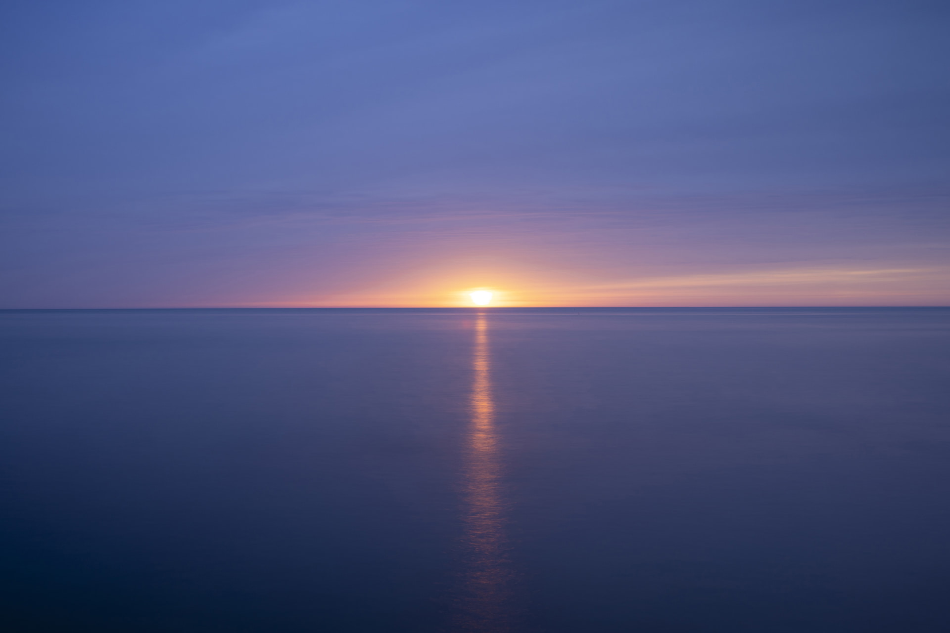 重たい雲に覆われた夕暮れの海を撮影しようと向かったが、太陽が水平線に落ちる寸前、雲が薄くなり光があふれてきた。わずかなグラデーションを60秒の露光でじっくりと写した<br><span class="fnt-85">キヤノン EOS R5／RF35mm F1.4 L VCM／35mm／マニュアル露出（F11、60秒）／ISO 100／WB：4,900K</span>