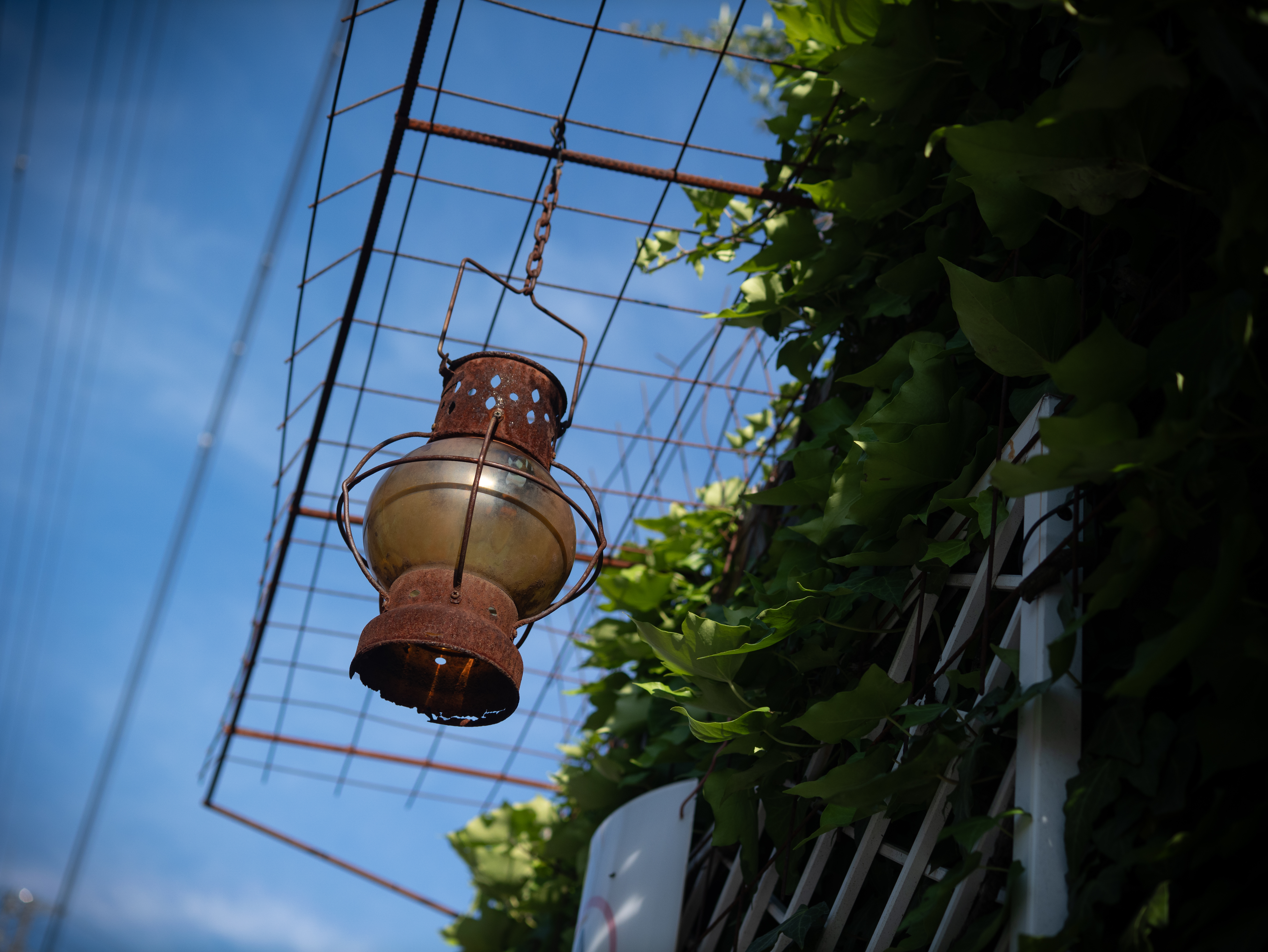 風でガンガン揺れていたランプが目に止まり、ここぞという時に連写して仕留めました。だからどうしたという作例ですが、青空バックの錆は必ず押さえなければなりません。<br><span class="fnt-85">パナソニック LUMIX G9PROII／ライカ・Dズミルックス25mm F1.4 ASPH.／25mm（50mm相当）／絞り優先AE（1/2,000秒、F2.5、−0.7EV）／ISO 100</span>