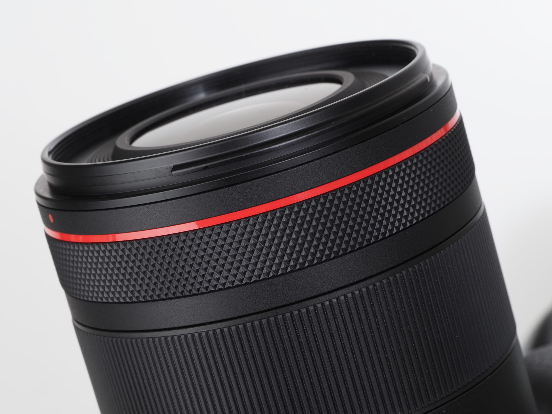 Lレンズの証である赤ラインが先端に。その下がコントロールリングです。静止画ではアイリスが使えないので、絞りを割り当ててみました。レンズはフッ素コーティングしてあるので付着した汚れを簡単に取り除けると。本当ですか？