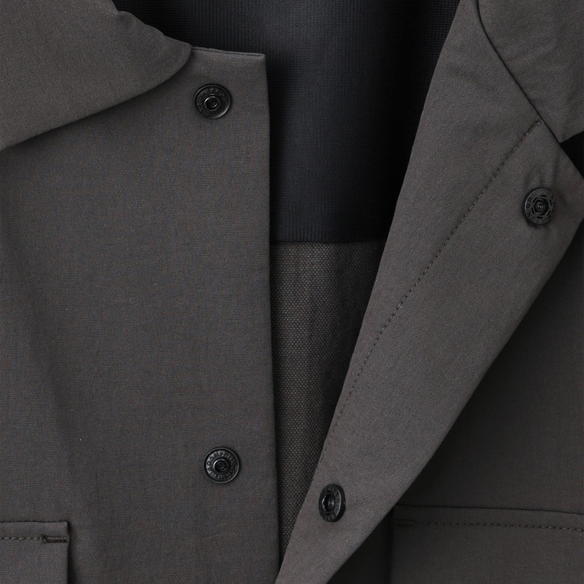シャツジャケットは二重の前立てによりボタンが隠れるデザインに。襟元や首回りをすっきりした印象に仕立てている