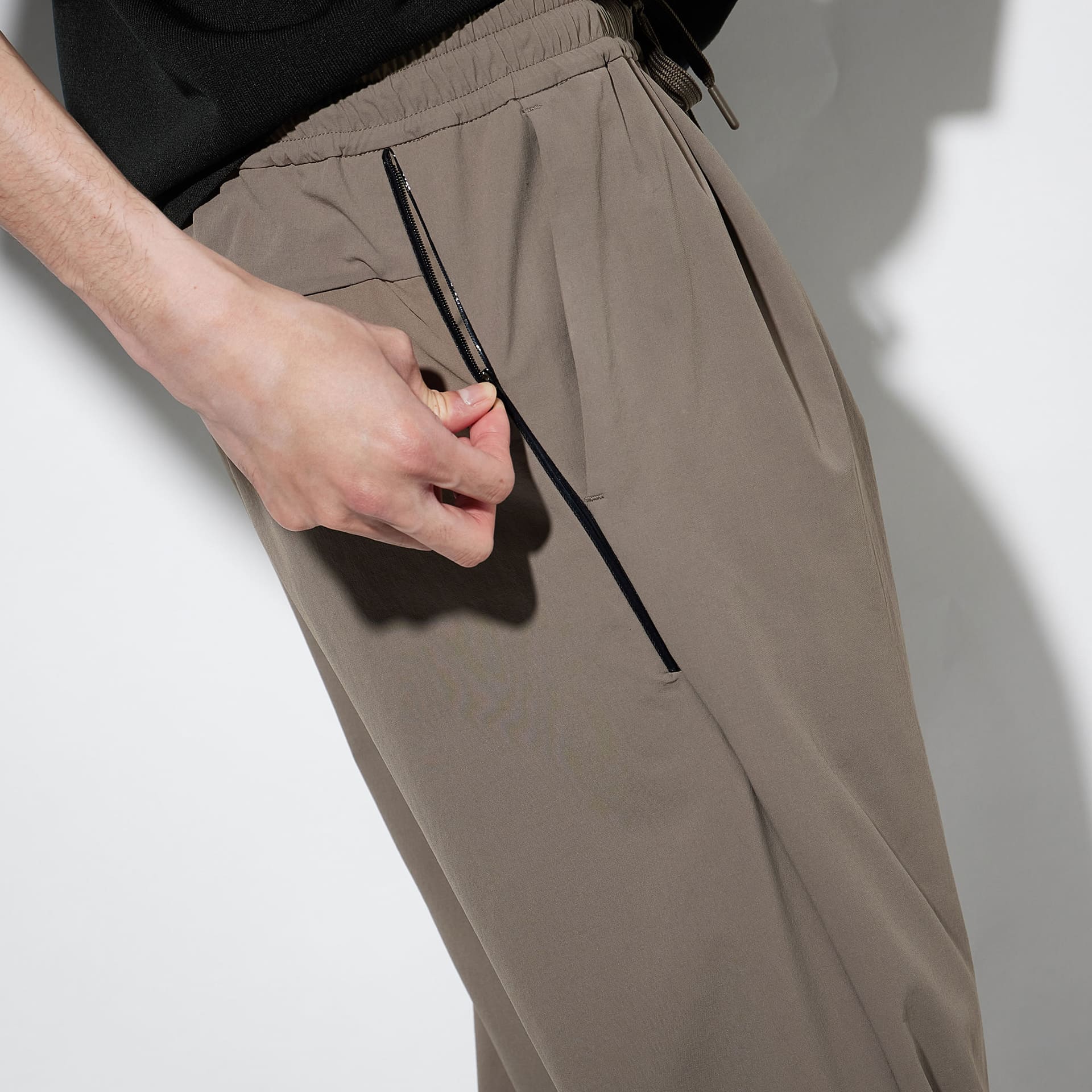 ジョガーパンツはサイドポケットにシリコン皮膜ファスナーを採用。細いラインをアクセントにした
