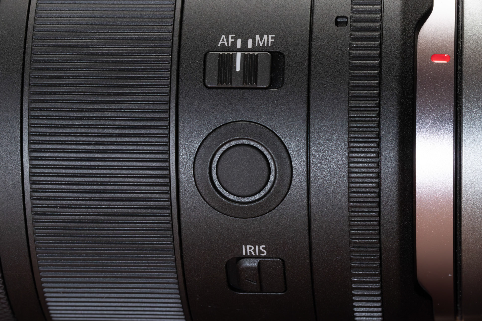 機能を割り当てられるレンズファンクションボタン（中央）も備える。下はアイリスリングロック解除スイッチ