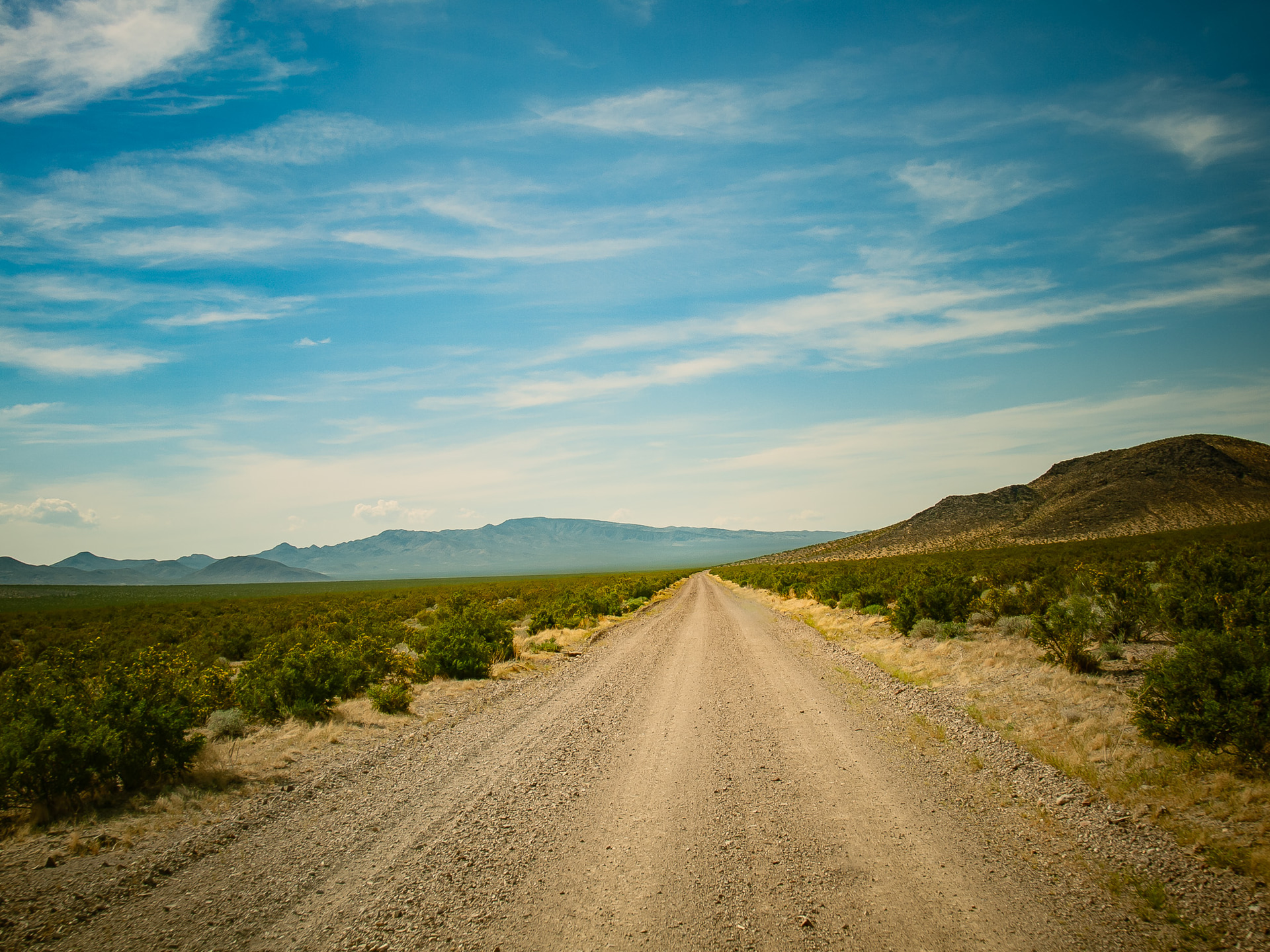 デスバレー周辺の未舗装路。本文の場所とは違いますが基本はフラットな砂利道です。どこまでも長い直線、人の匂いのない風景。寂寥感と自由さ、孤独さ、そして厳しい自然を開拓した人々のことなどさまざまな想いが一度に押し寄せてくる風景。もう一度行きたいなあ。