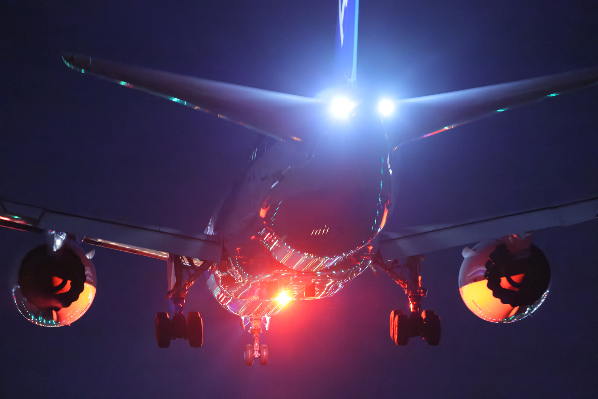 至近距離を時速200kｍ超で通過する機体。滑走路の光が反射して輝く一瞬を30コマ/秒の高速連写で捉えた。AF精度とブラックアウトしないファインダーは夜間撮影の味方だ<br><span class="fnt-85">キヤノン EOS R5 Mark II／RF100-300mm F2.8 L IS USM／175mm／マニュアル露出（F2.8、1/60秒）／ISO 25600／WB：2,700K／ニューラルネットワークノイズ低減（標準）</span>