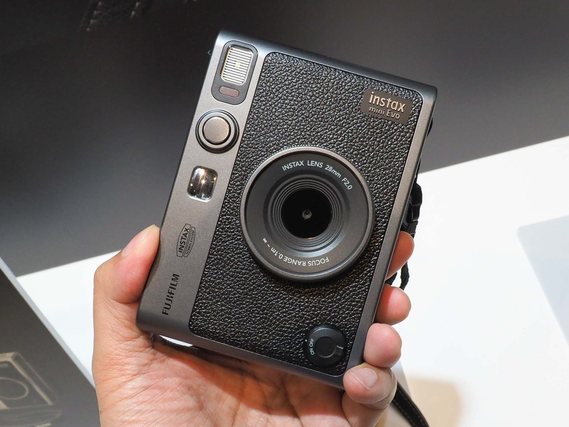 「instax mini Evo」の特別仕様モデル「FUJIFILM 90th Anniversary Special Kit」。左がDARK SILVER、右がTITANIUM GOLDレンズキャップとストラップも特別仕様となっている