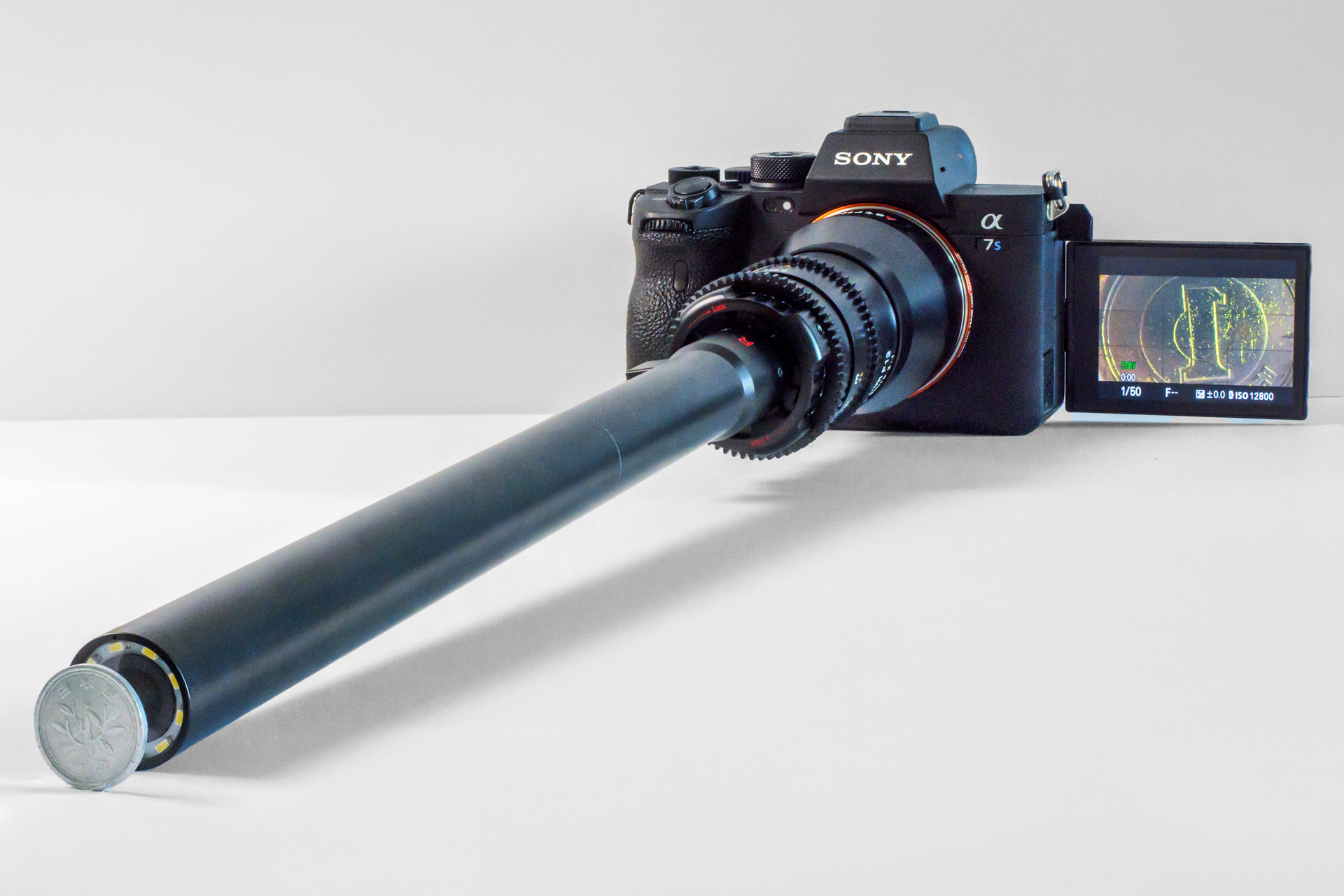 最短撮影距離に1円玉を置いた状態。その間隔は指先が入らないほどに狭い。この距離で撮影すると、1円玉の「1」の文字を横向きの画面いっぱいに撮影できる（35mmフルサイズカメラの場合）