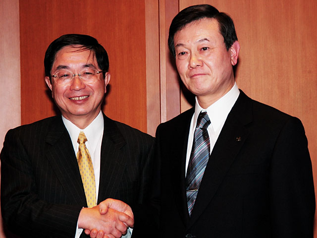 オリンパスイメージング株式会社の小宮弘社長（当時、左）と、松下電器AVCネットワークス社長の大坪文雄氏（当時、右）