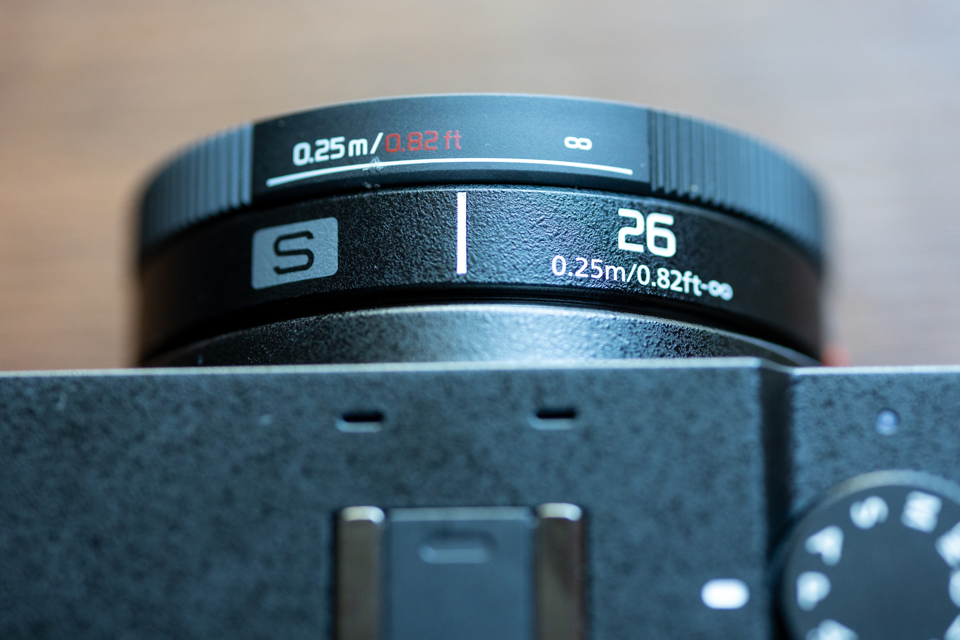 LUMIX 26mm F8のフォーカスリングの距離指標。MFレンズなのにインフと最短0.25mの表記しかありません。目測設定は難しくなります。自分で合焦位置を確かめ、その時の距離を測り、フォーカスリングに距離をマークするなどして対処できるかもしれませんが面倒ですね。