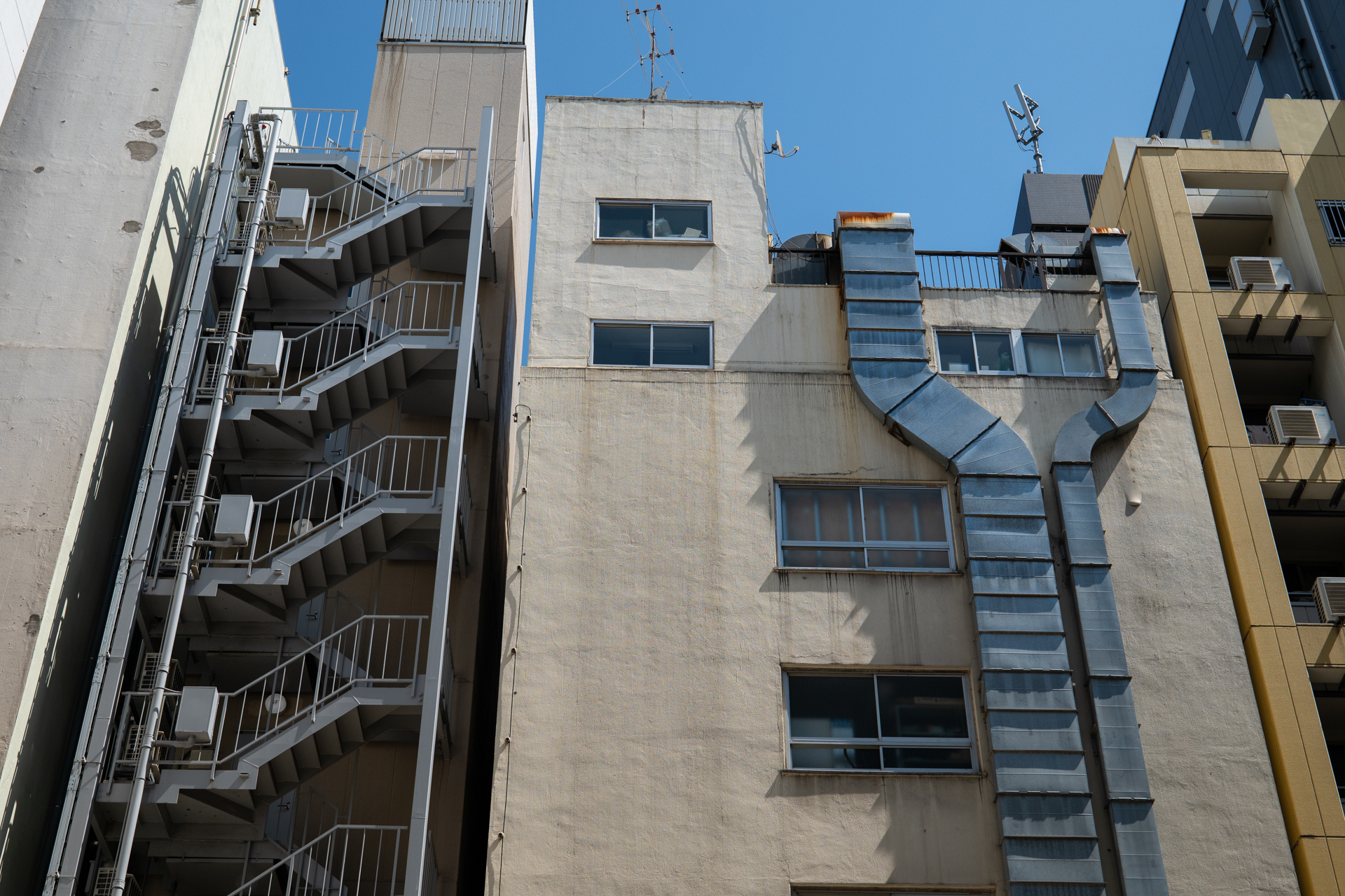 都市部でビルが壊されると隣接したビルの側面が白日のもとにさらされてしまいます。ダクトが恥ずかしそうです。新しい建物ができれば2度と見ることはできないでしょう。すばらしきシャープネスです。<br><span class="fnt-85">パナソニック LUMIX S9／LUMIX S 50mm F1.8／プログラムAE（1/1,000秒、F7.1、−0.7EV）／ISO 400</span>