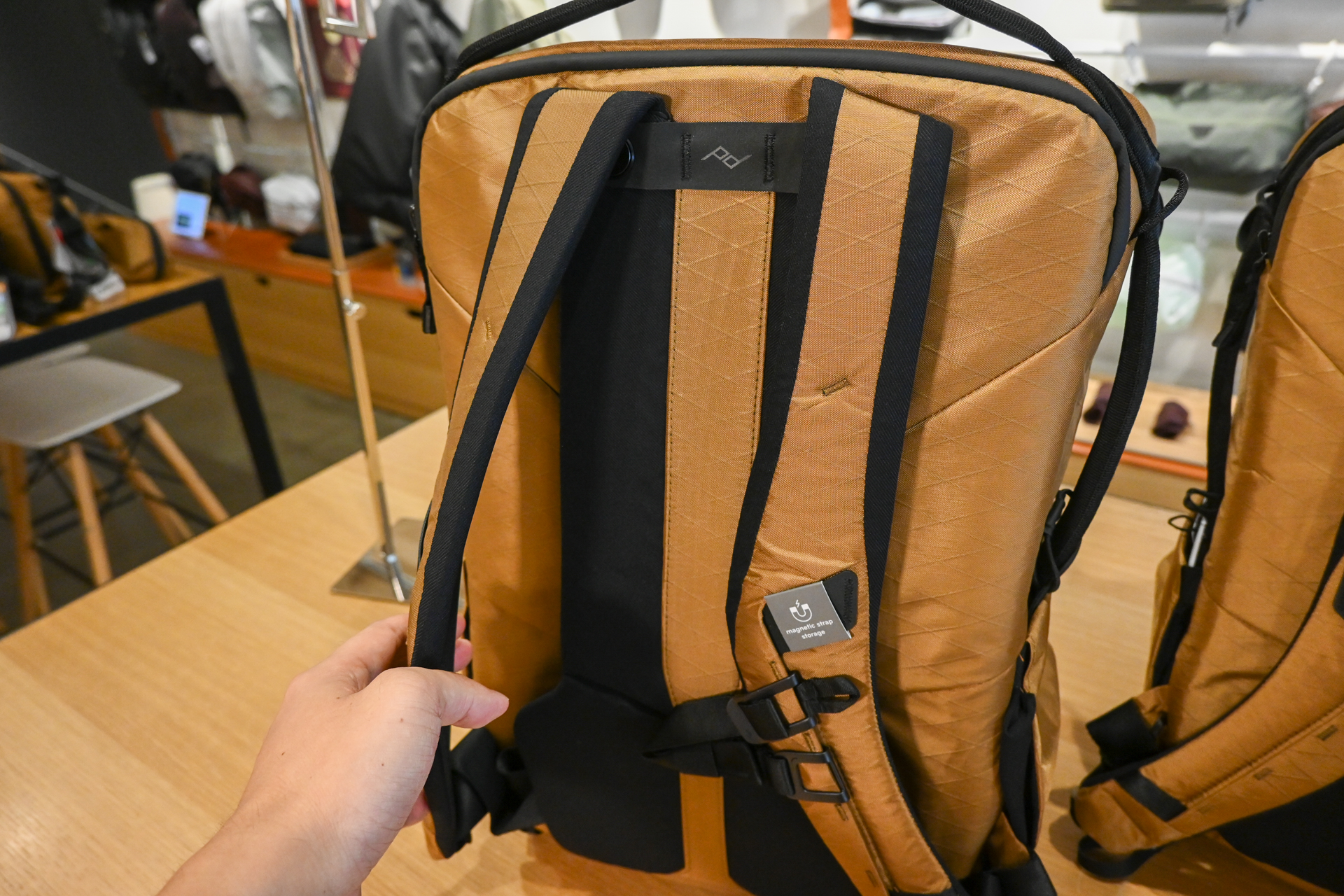 ショルダーストラップはマグネットで背面にくっつくようになっている。バッグをいた時にストラップ部分がかさばらないのがよい