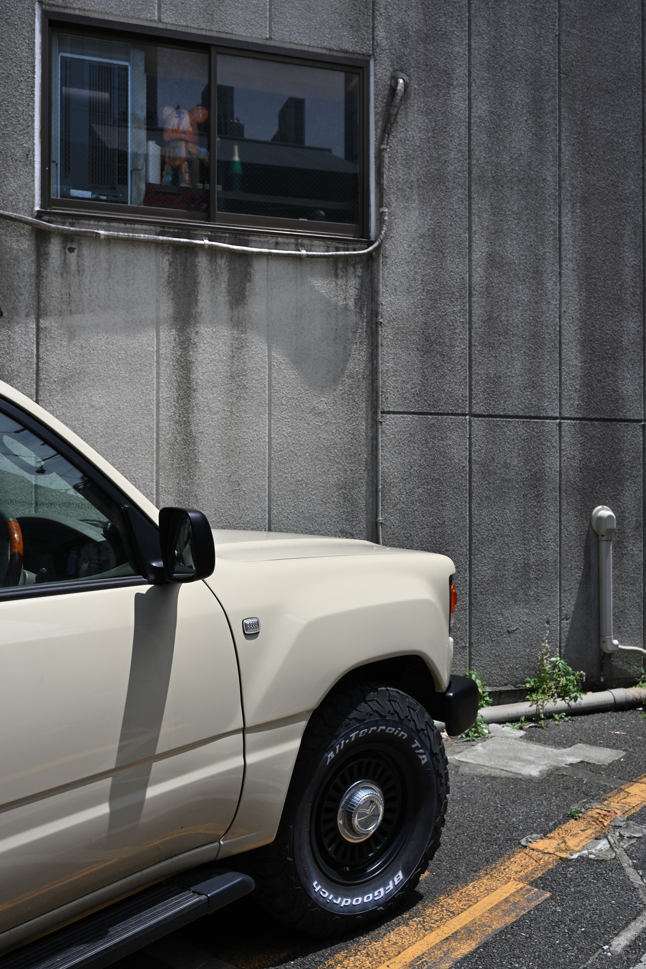 駐車場の片隅にて。ハードな雰囲気のクルマのボディ、背景のコンクリートなどの描写もたいへんけっこうであります。<br><span class="fnt-85">ニコン Z6III／NIKKOR Z 35mm f/1.4／絞り優先AE（1/500秒、F8.0、−0.7EV）／ISO 100</span>