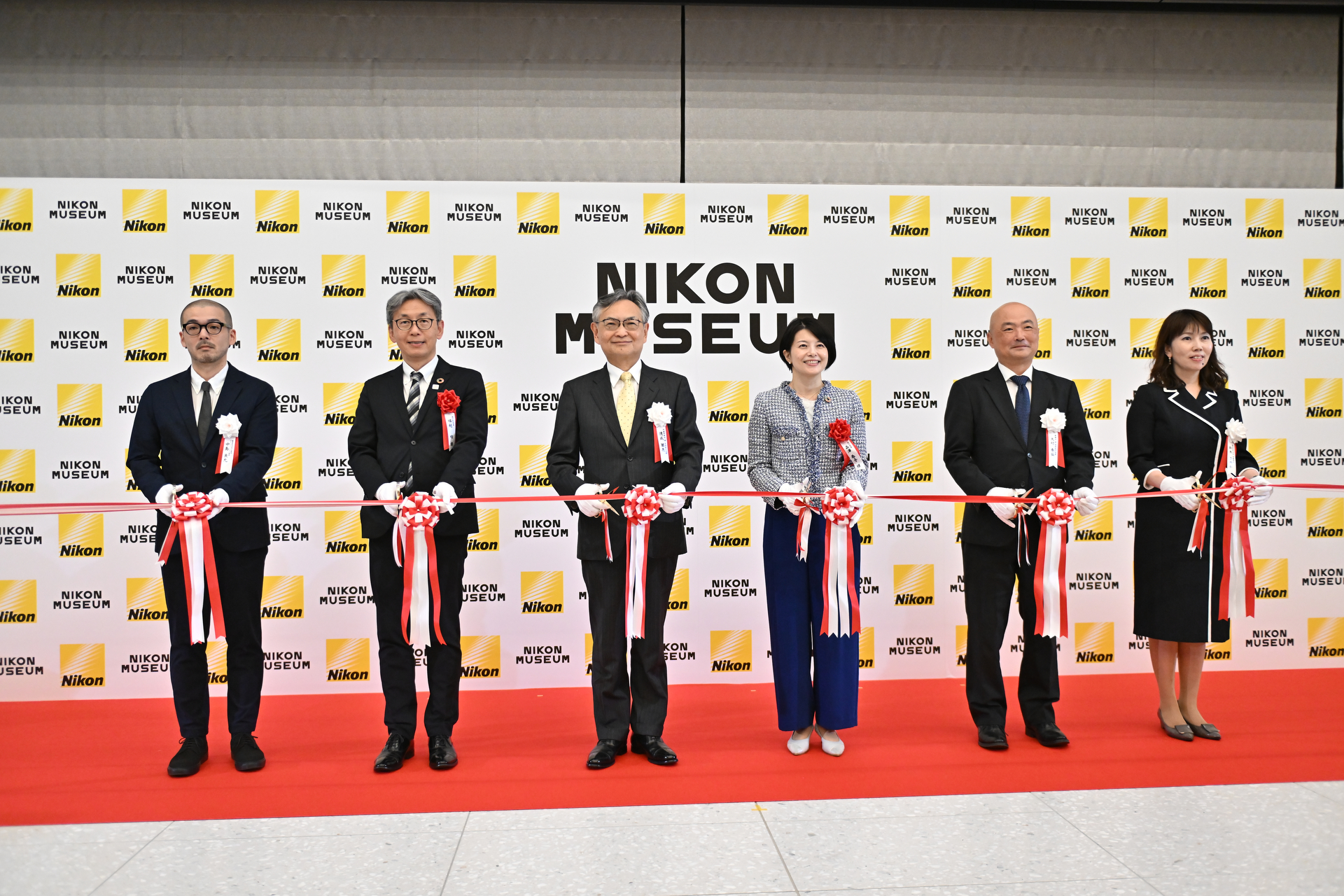 テープカットの様子。左からニコンミュージアム館長の中島良允氏、品川市副区長の堀越明氏、ニコン代表取締役兼社長執行役員の德成旨亮氏、品川区長の森澤恭子氏、ニコン取締役兼執行役員の大村泰弘氏、ニコン経営戦略本部広報部長の鈴木さやか氏