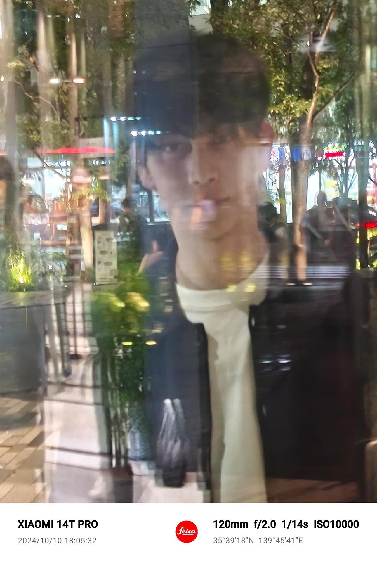 ガラス越しのモデルを写真モードの120mmで撮影。暗い上に写り込みも多いなか、顔にピントを合わせることができた