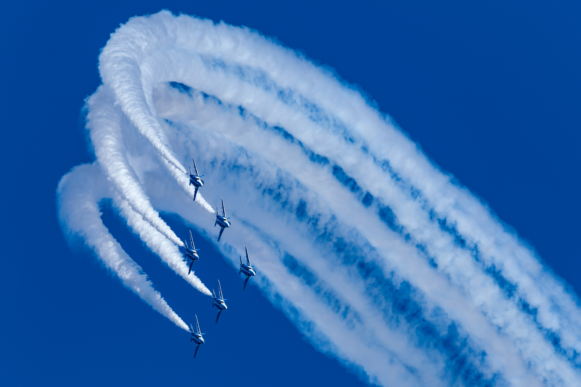 会場の左側から進入し、大きく回転していく「デルタ・ロール」は6機がそろう最初の課目。スモークを入れながら機体を撮ると、奥行きを出しやすい。<br><span class="fnt-85">EOS 6D／EF100-400mm F4.5-5.6L IS II USM／400mm／絞り優先AE（1/1,600秒、F6.3、＋0.67EV）／ISO 400</span>