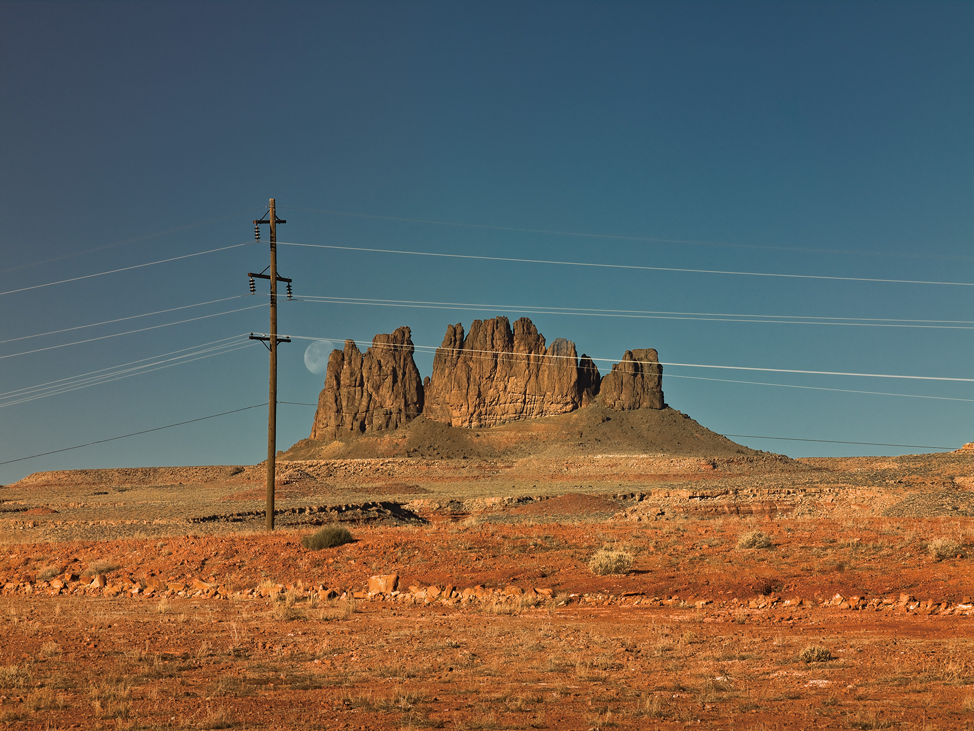 2009年アメリカ、モニュメントバレー近くで。この頃アメリカ中西部に足繁く通い、個展を何回か開いたのだけど、当初アメリカの風景として期待してたのは、どこまでも広がる大自然だった。だけどね、確かに大自然が広がっているんだけど、そこここに人の営みの匂いがするんだよね。むしろそこに魅力を感じたんです。どこまでも続く道路、どこまでも続く電線。電線の先には必ず人が暮らしているはずで、抜けの良い荒野の風景の中、人が暮らしていると思うと新大陸の開拓の歴史さえ思ってしまう。それはずでに浪漫でしかないのかも知れないけど、車窓を行き過ぎるこうした風景はとても魅力的だった