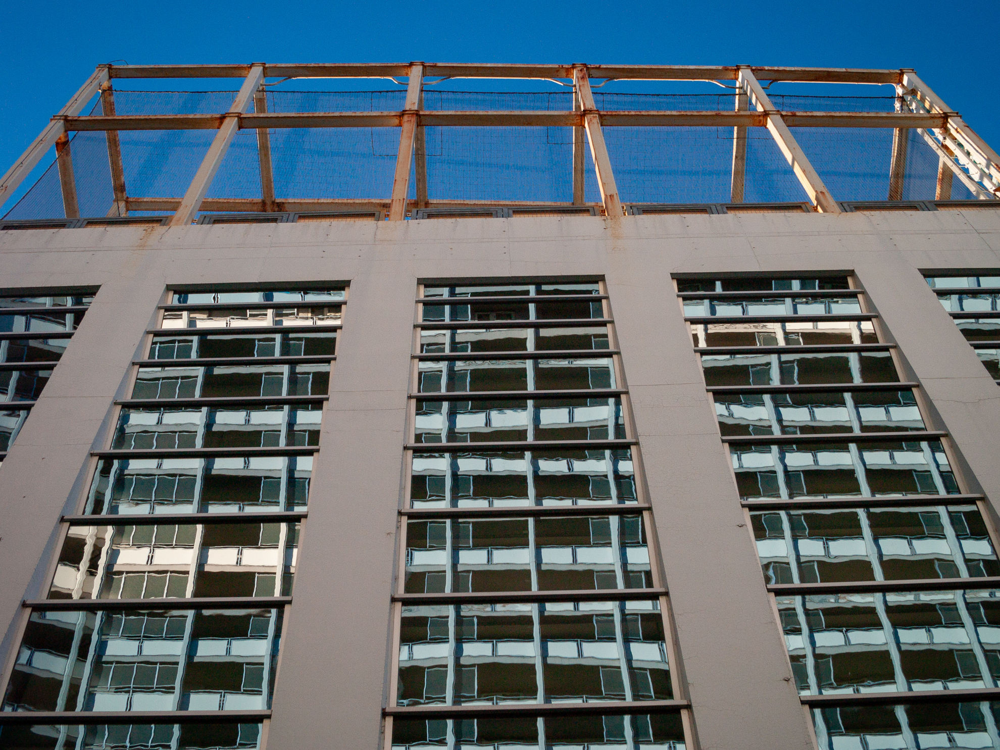 建物を見上げたら、ビルの窓に、隣のビルのリフレクションを見つけました。このレンズ、直線部をみるとわずかにタル型の歪曲があることがわかりますね。補正しないでそのまま出します。<br><span class="fnt-85">オリンパス E-400／ZUIKO DIGITAL 25mm F2.8／25mm（50mm相当）／絞り優先AE（1/640秒、F8.0、−1.0EV）／ISO 400</span>