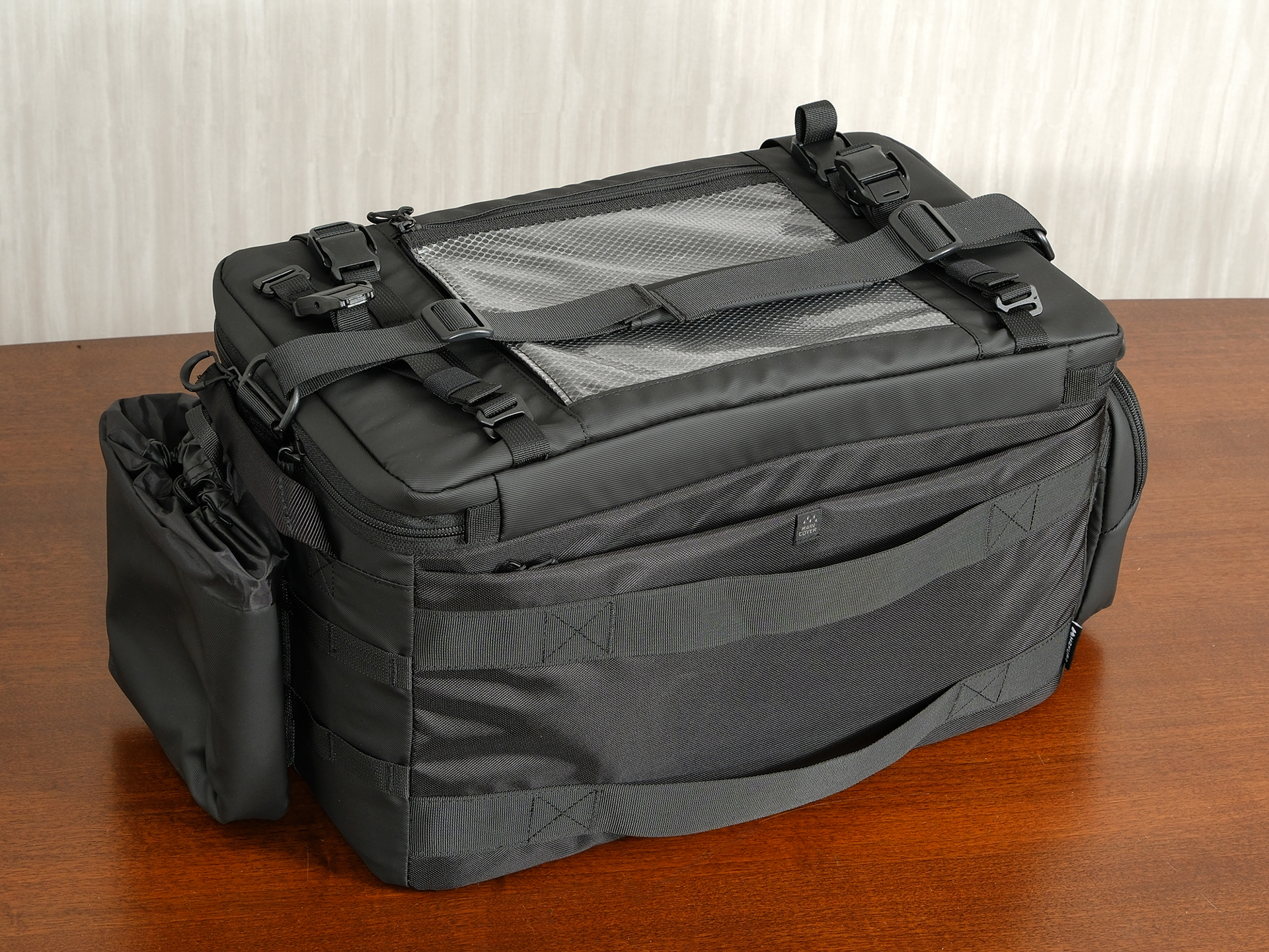 背面にはキャリーハンドルに取り付けるためのベルトを装備