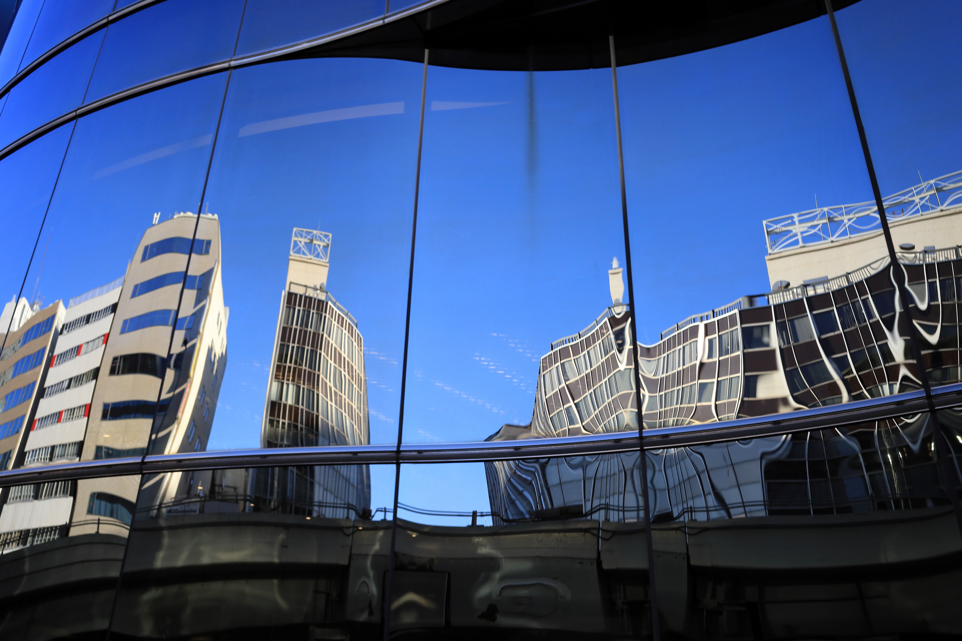 レンズが歪んで写るのではありません。曲がった窓に映るリフレクションであります。冬ということもあるでしょうけど、スカッと写りますね。<br><span class="fnt-85">キヤノン EOS RP／RF28mm F2.8 STM／28mm／プログラムAE（1/400秒、F7.1、±0.0EV）／ISO 400</span>