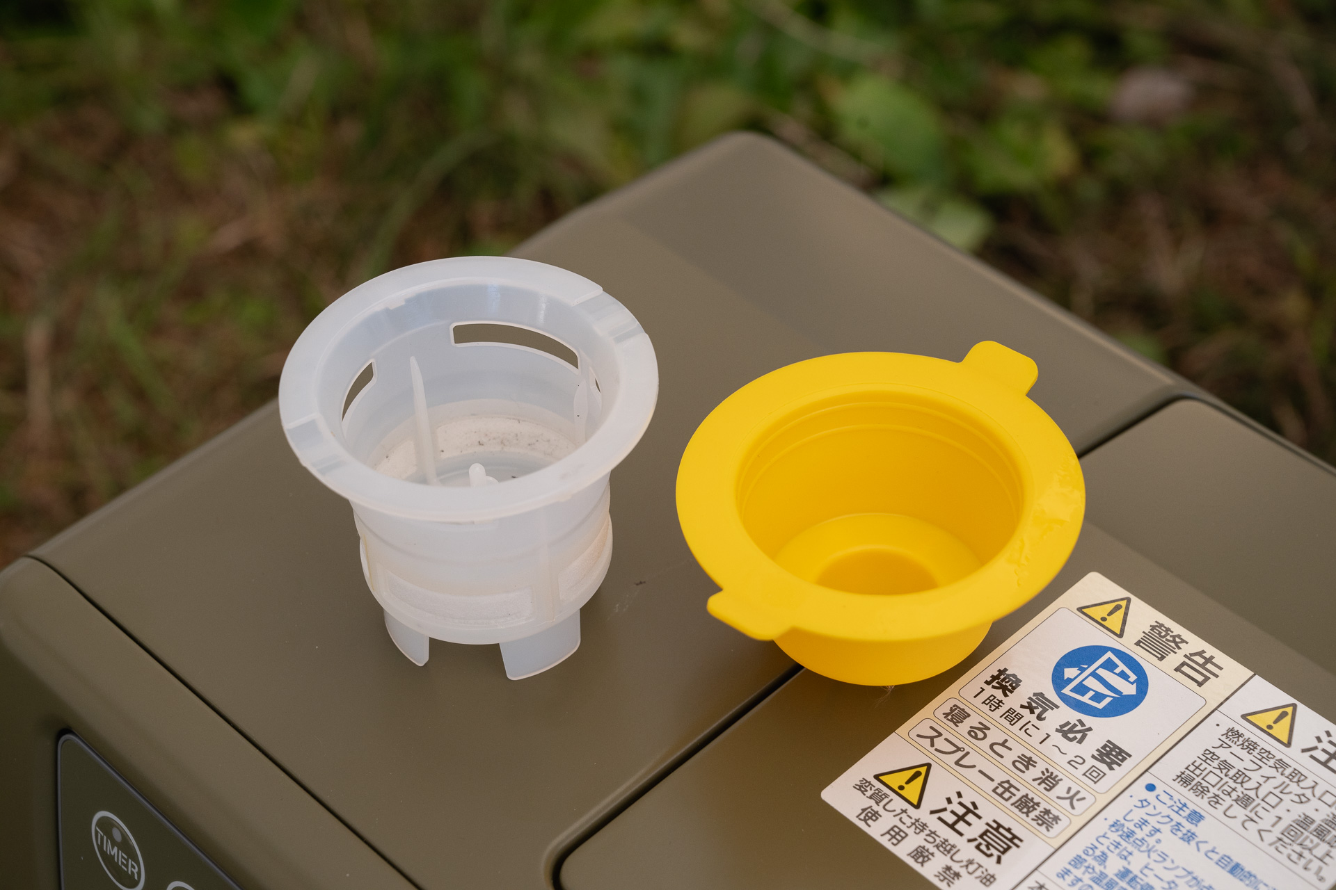 左の白いものは燃料タンクのストレーナー。ゴミ混入防止のためのもの。右の黄色ものは運搬時の燃料漏れ防止キャップ