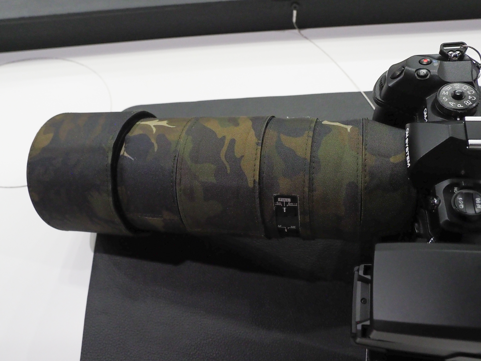 OM SYSTEMオリジナル カモフラージュレンズカバーを装着したモデルも