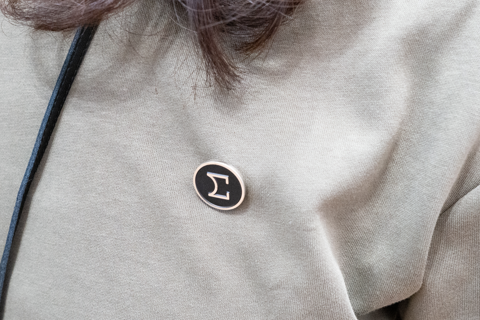 シグマスタッフが胸に付けているバッジ。創業時から使っていたシンボルマークを再解釈したものだという