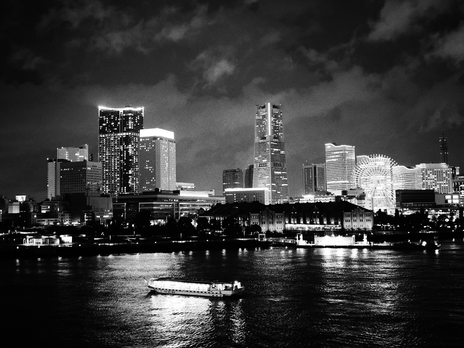 しっとりとした雨の夜に横浜にて撮影した。防塵・防滴性能が備わっているOM SYSTEM OM-3であれば、雨の中でも安心してスナップ撮影が可能である。近代的な高層ビル群とクラシックな屋形船の対比が面白かった<br><span class="fnt-85">M.ZUIKO DIGITAL ED 20mm F1.4 PRO／20mm（40mm相当）／絞り優先AE（F1.4、1/60秒、＋1.0EV）／ISO 6400／WB：オート</span>