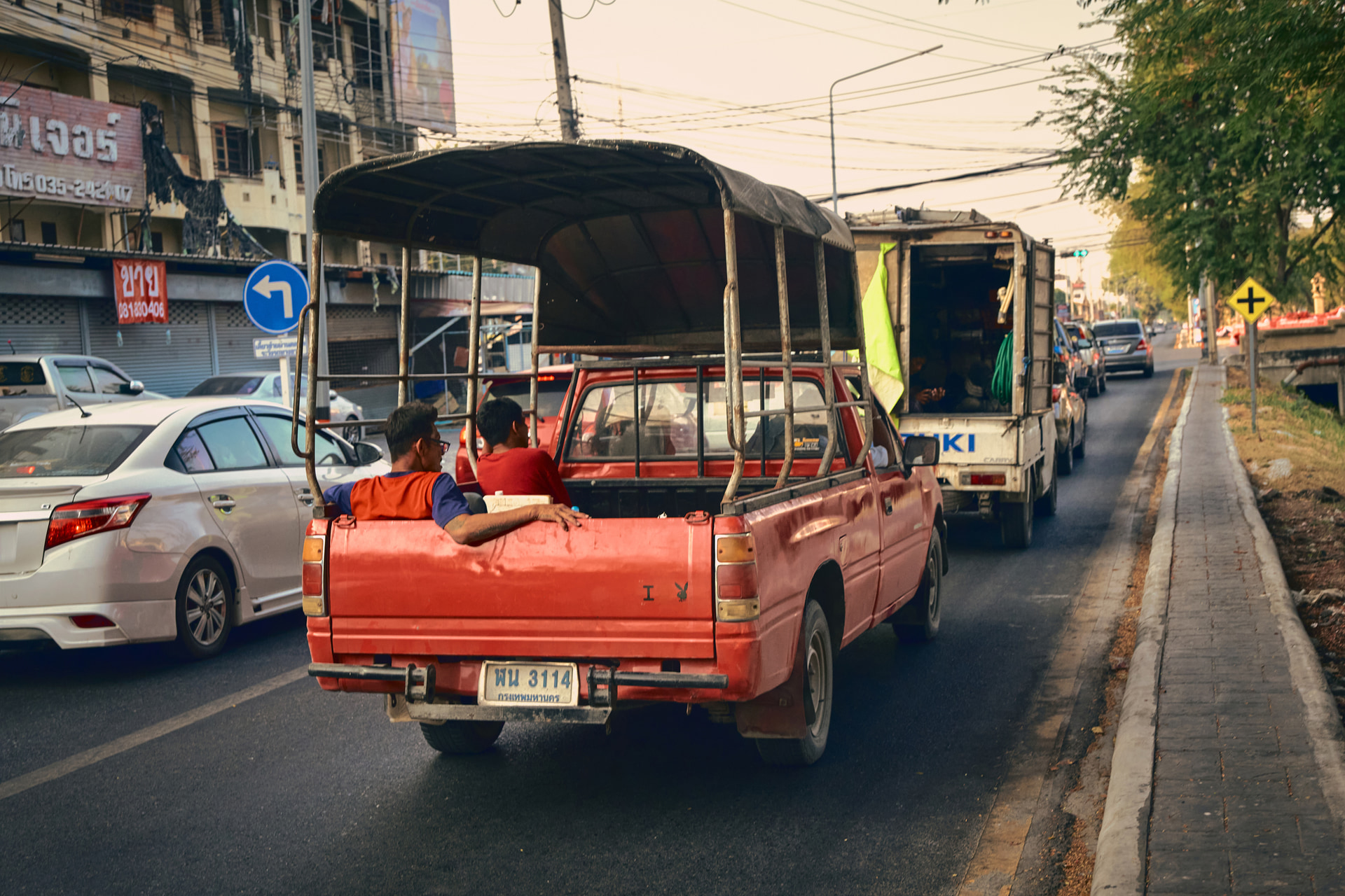 前を走るトラックの荷台に乗る人たちを見つけた。とっさのシャッターチャンスを30コマ/秒で高速連写。撮影後にモニターで確認すると、ピントも問題なく、皆リラックスした表情をしている。こんなことからもタイ人の温厚な人柄を感じられた<br><span class="fnt-85">ライカSL3-S／ライカ バリオ・エルマリートSL f2.8-4/24-90mm ASPH.／49mm／マニュアル露出（F5.6、1/125秒）／ISO 1250／WB：オート</span>