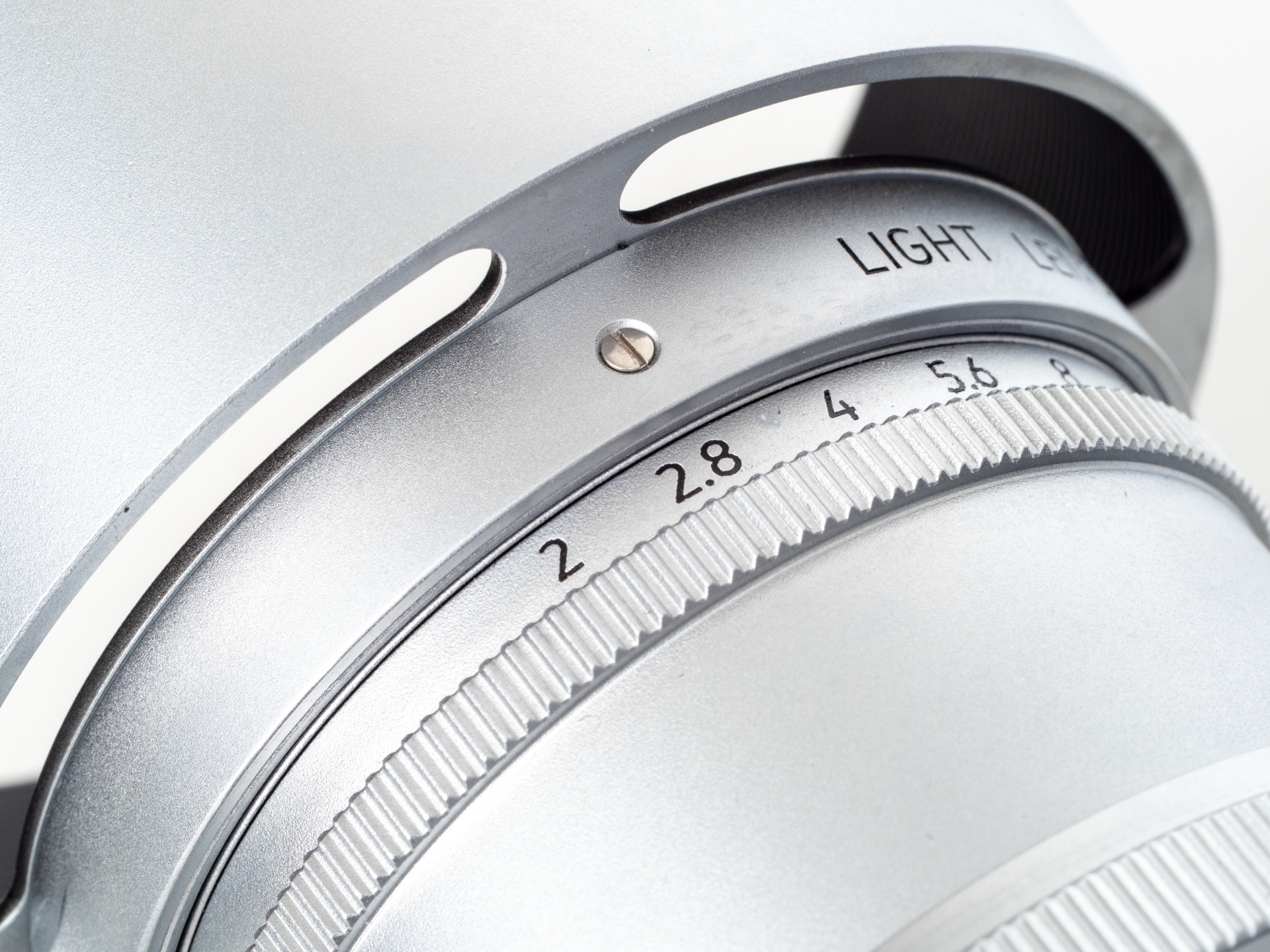 スリットの入ったフード。光学ファインダーを使用する場合は有益であります。カブセタイプなので、装着すると指標が隠れてしまいます。マイナスネジのところに絞りを合わせてねということです。