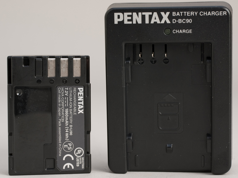 <b>リチウムイオン充電池「D-LI90」とバッテリーチャージャー「D-BC90」（右）</b>