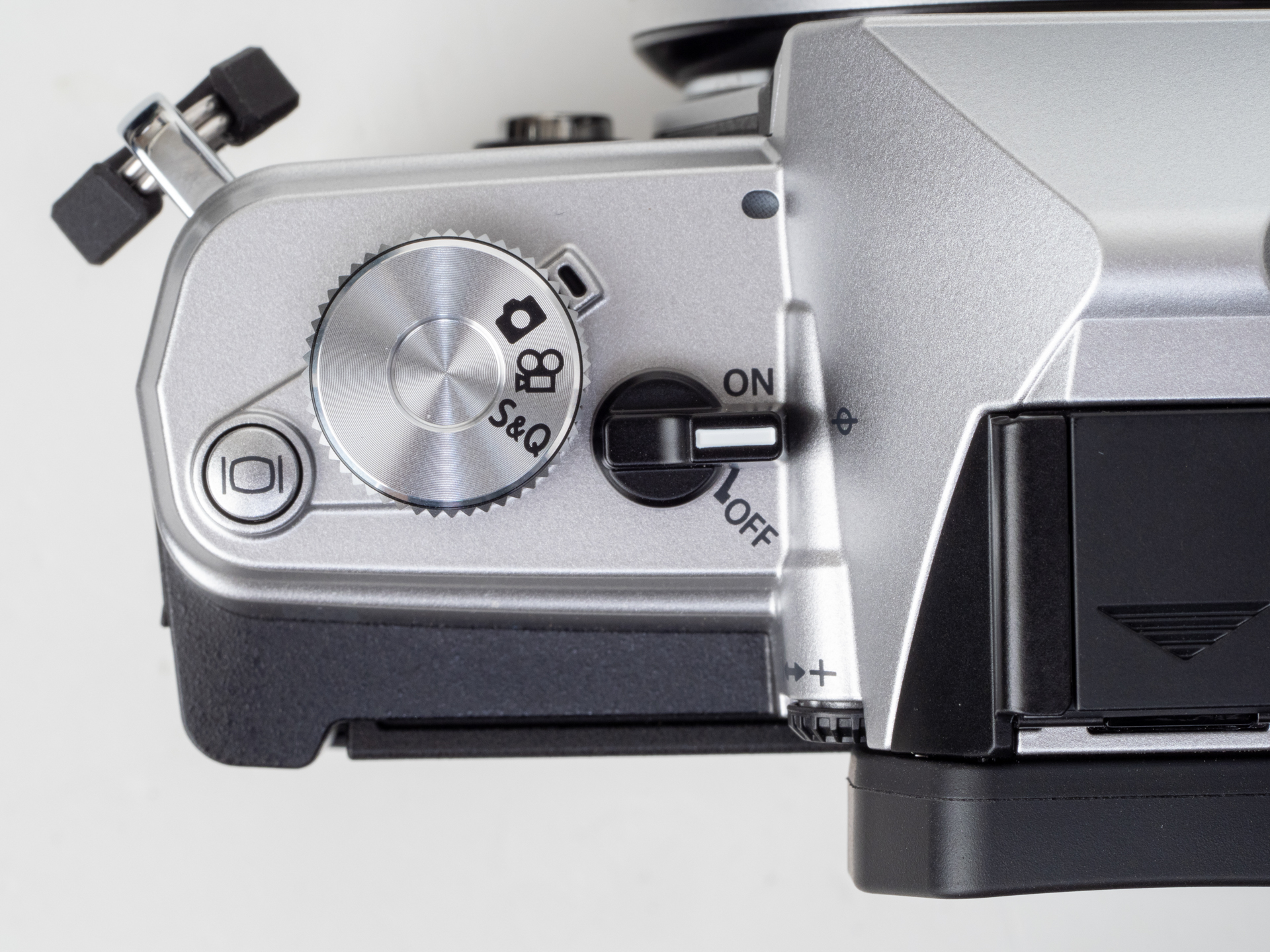 メインスイッチのレバーはもっと堂々としていていいんじゃないのかなあ。静止画、動画の切り替えはこのダイヤルを使いますが、指標が2時方向というのがよくわからないですね。メインスイッチの白線と並行に並んだアイコンが現在その機能を果たすという方が良くないですか。