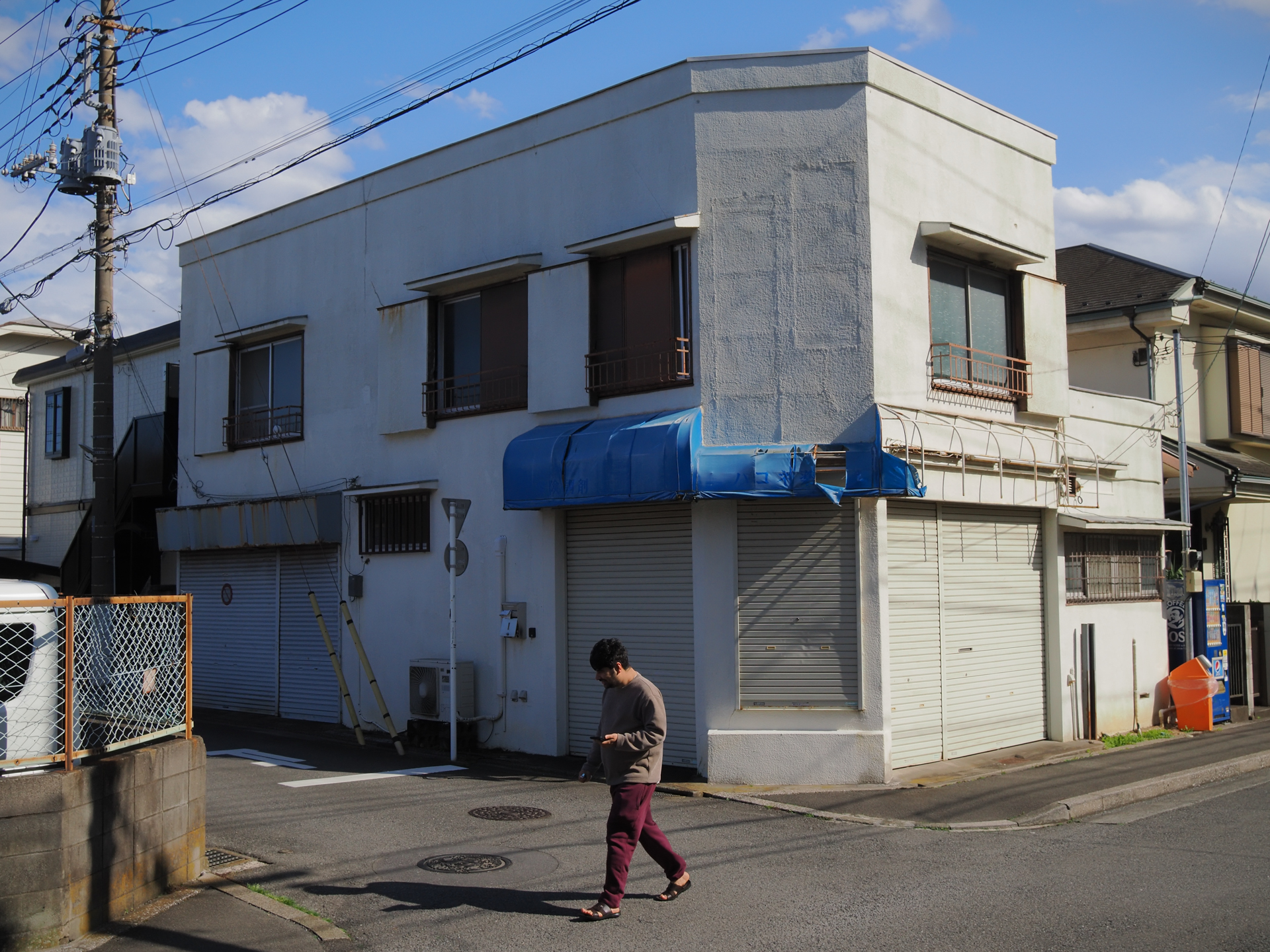昭和感たっぷりの街角です。建物を歪めたくないので、カメラを頭上に上げてバリアングルモニターを頼りにフレーミングしていますがきっちり実直に描写されました。<br><span class="fnt-85">OM SYSTEM OM-3／SIGMA 19mm F2.8 DN／19mm（38mm相当）／プログラムAE（1/1,000秒、F8.0、−0.7EV）／ISO 400</span>