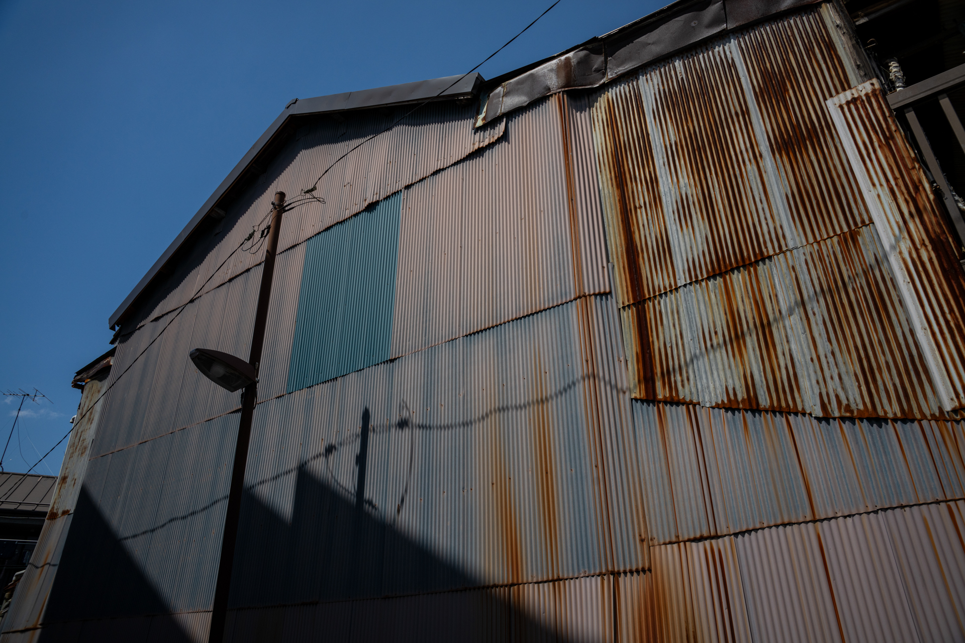 錆びたトタンの向こうに青空ですから大好物であります。24mmのパースペクティブを利用してみます。<span class="fnt-85">ソニー α7CR／Vario-Sonnar T＊ 24-70mm F2.8 ZA SSM／24mm／絞り優先AE（1/2,000秒、F8.0、−0.3EV）／ISO 400</span>