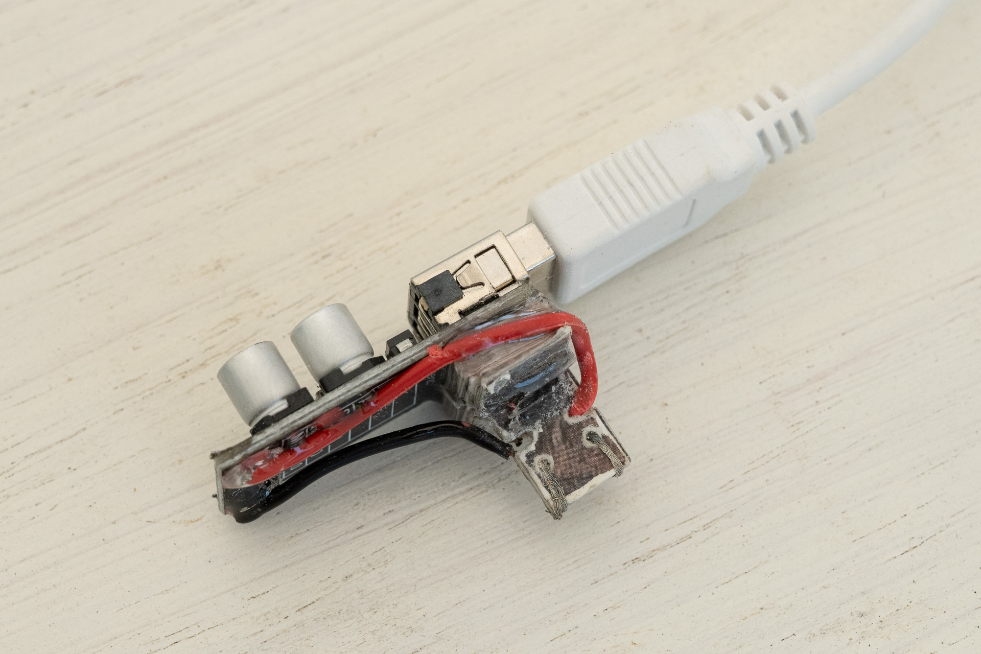 降圧コンバータを加工します。台になってる部分と端子は余ってた絵葉書を切って重ねて瞬間接着剤で固めたもの。接点はリード線そのまま