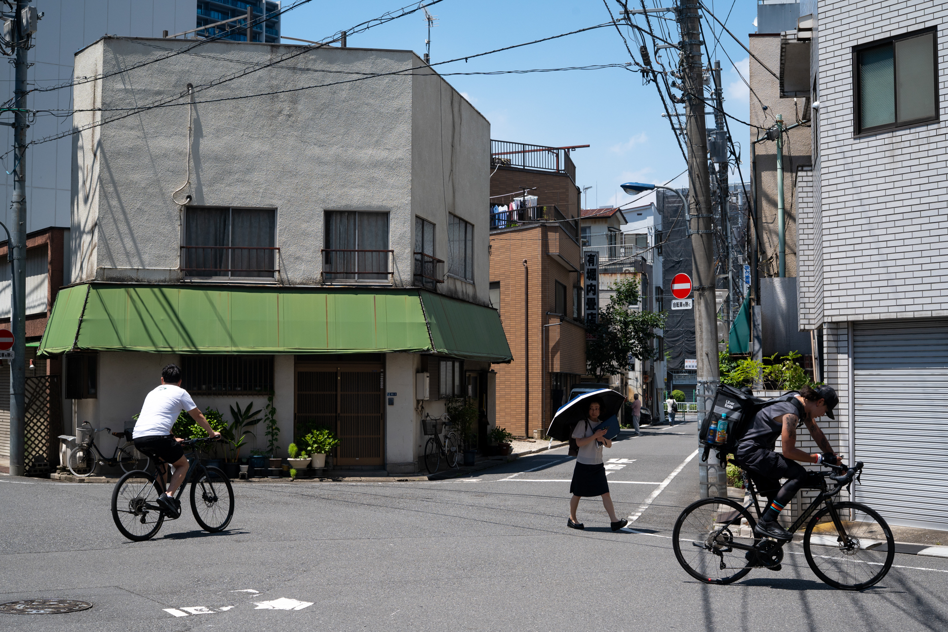 街角で。東京の下町だと、引きのとれる場所は限られることが多いのですが、50mmの画角がハマるとよい感じに撮れます。湿度のためか、レンズの特性か、少しヌケが悪いですね。<br><span class="fnt-85">ニコン Df／ニッコールHオート50mm F2／F8</span>