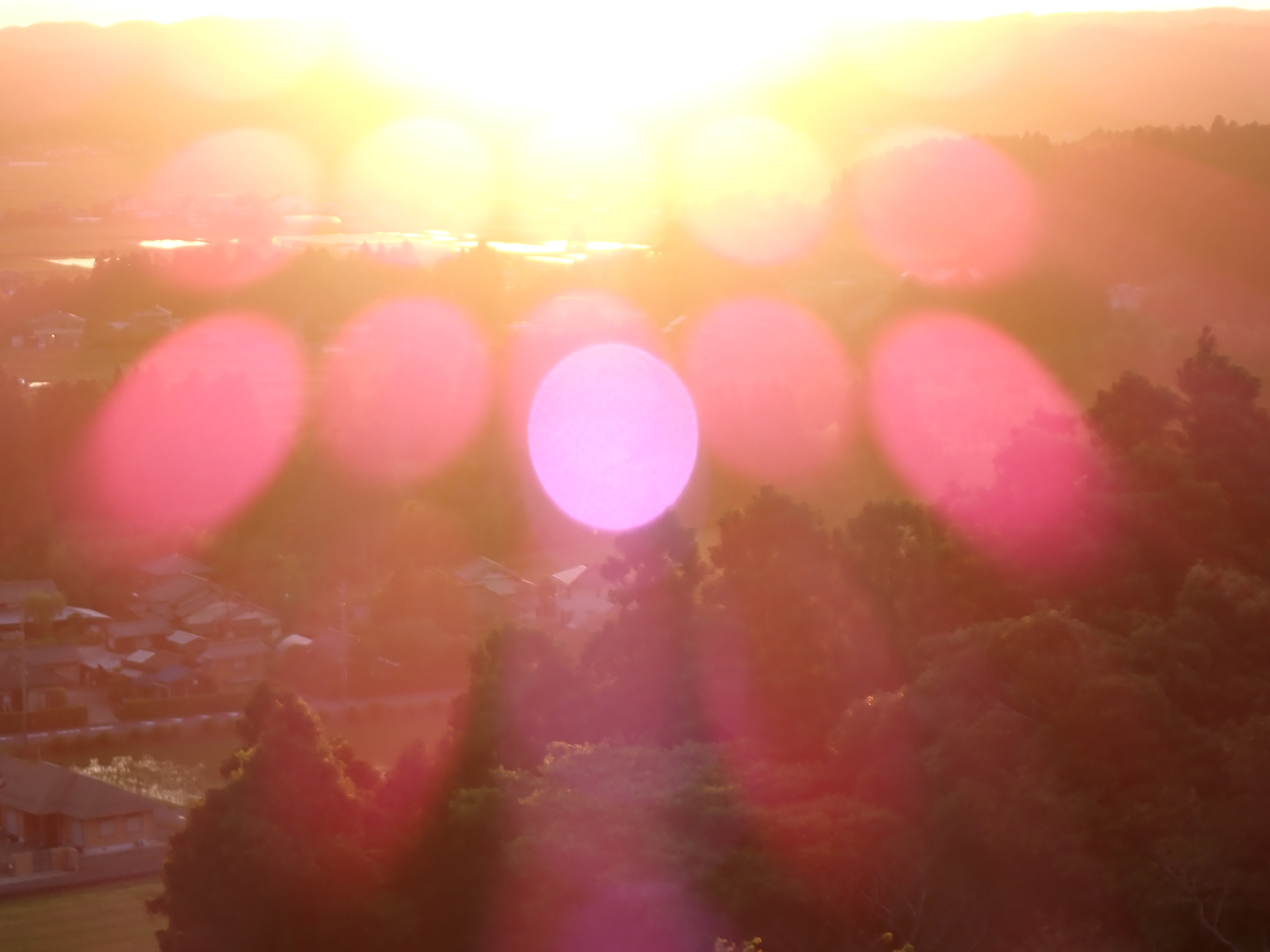 テレ端で夕陽を撮る。屈曲光学系であるゆえか、たくさんのゴーストが出るポイントがある。焦点距離を変えたり、ほんの少しフレーミングを変えるだけで消えてしまうがフィルター効果的に楽しんだほうがいいでしょう。フレアはTG-5より減っている<br>OM SYSTEM TG-7／（1/13秒、F4.9）／ISO 100