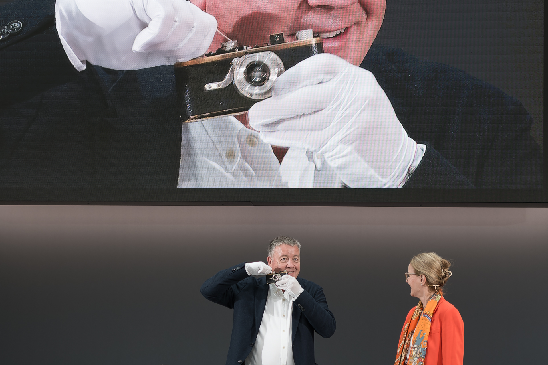 「ライカI」の空シャッターを切り、巻き上げノブを回してチャージ音を聞く場面。「100年前の製品が今でも使えることほど、メーカーとして困ることはない」といったジョークも飛び出すほど。カメラを手にするのは上級副社長のステファン・ダニエル氏