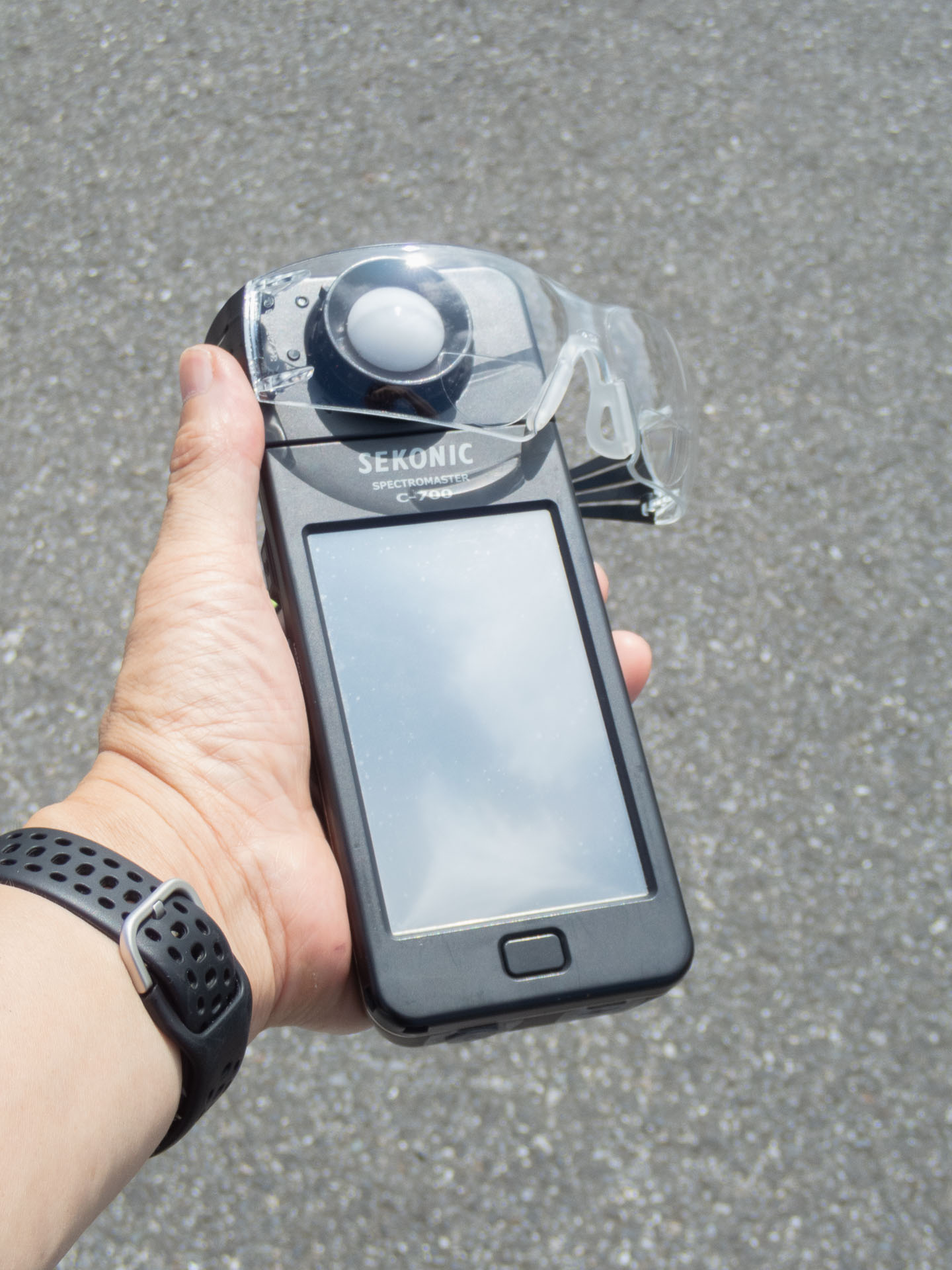 C-700の受光球に3Mセキュアフィット保護メガネを被せるようにして計測。右は比較用にレイバンのサングラスを計測した