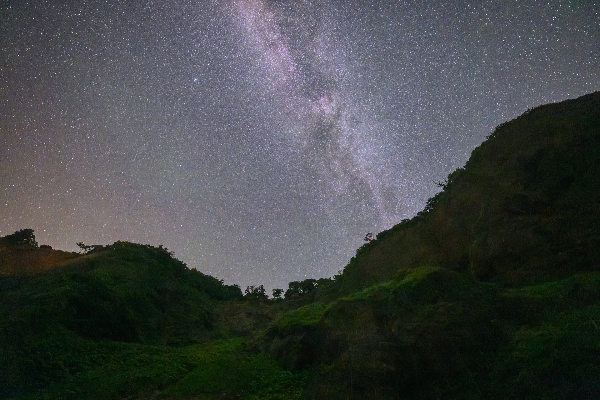 北海道様似町の海岸沿い。この日は湿度が高く海側の星空の写りはシャープではなかったが、後ろ側を撮影すると、断崖絶壁の向こうにはくちょう座付近の天の川が力強く輝いていた<br><span class="fnt-85">ニコン Z8／NIKKOR Z 14-24mm f/2.8 S／14mm／マニュアル露出（F2.8、15秒）／ISO 8000／WB：晴天</span>