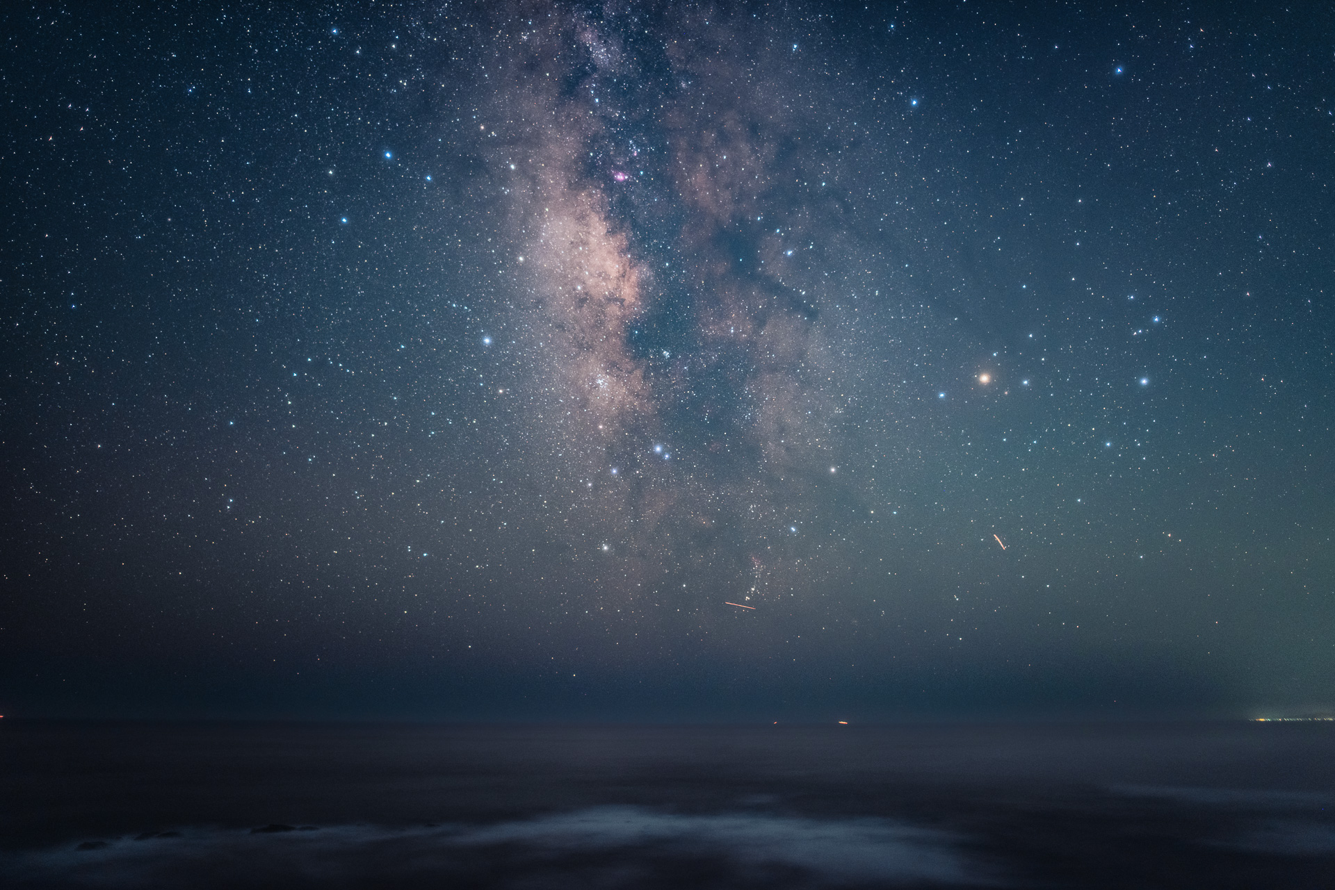 夏！ といえば天の川ですね！ 8月は地表から天に向かって立ち上がるような、直立する天の川を見やすい季節。8月中ばなら時刻は21時頃から23時頃。日中の暑さもひいた時間にちょっと散歩はどうでしょう。南の空を見てください。写真では肉眼で見える以上に写るので迫力がでてますけど、肉眼では入り組んだディテールまでは見えません。だけど、空の暗いところならはっきりと明るい川が流れているような様子を見ることができます。できれば高い山や沖縄県、なかでも石垣島に行きたいところですが、関東近辺でも南房総や伊豆などではよく見えますよ。昼は海水浴、夜は天の川観察なんてどうです？ 寝不足には注意してね！ ちなみにコレ撮影したの千葉県鴨川市です〜