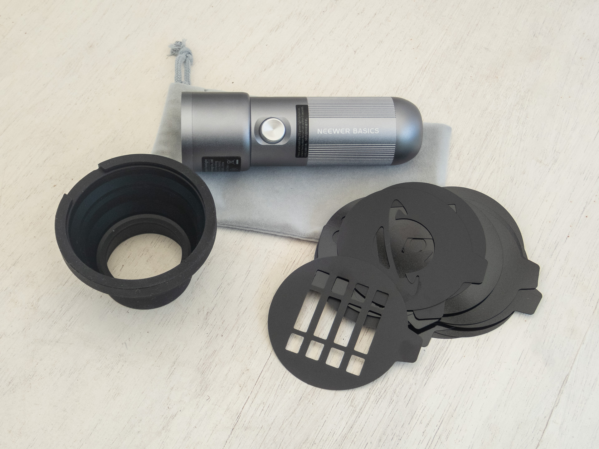 左の黒いフードのようなアダプターに右のマスクを嵌めてつかう。アダプターはシリコン製で折り畳みできるのでコンパクトにまとめられる。