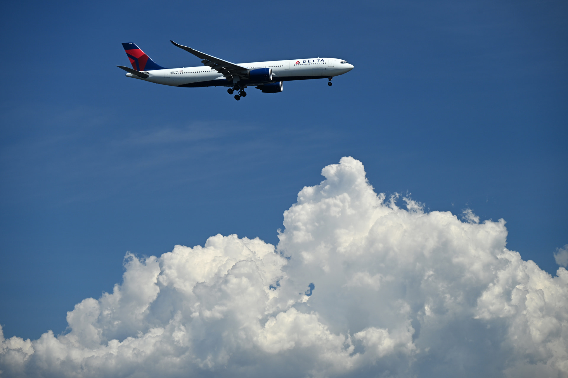 <span class="fnt-110"><b>夏空に浮かぶ入道雲の白さを際立たせる</b></span><br>C-PLフィルターを効かせて空の明るさを落とし、夏の青空にモクモクと育った入道雲と着陸機の存在感を強調した<br><span class="fnt-85">ニコン Z8／NIKKOR Z 24-200mm f/4-6.3 VR／130mm／シャッター優先AE（F6.3、1/1,000秒、±0EV）／ISO 320／WB：晴天</span>