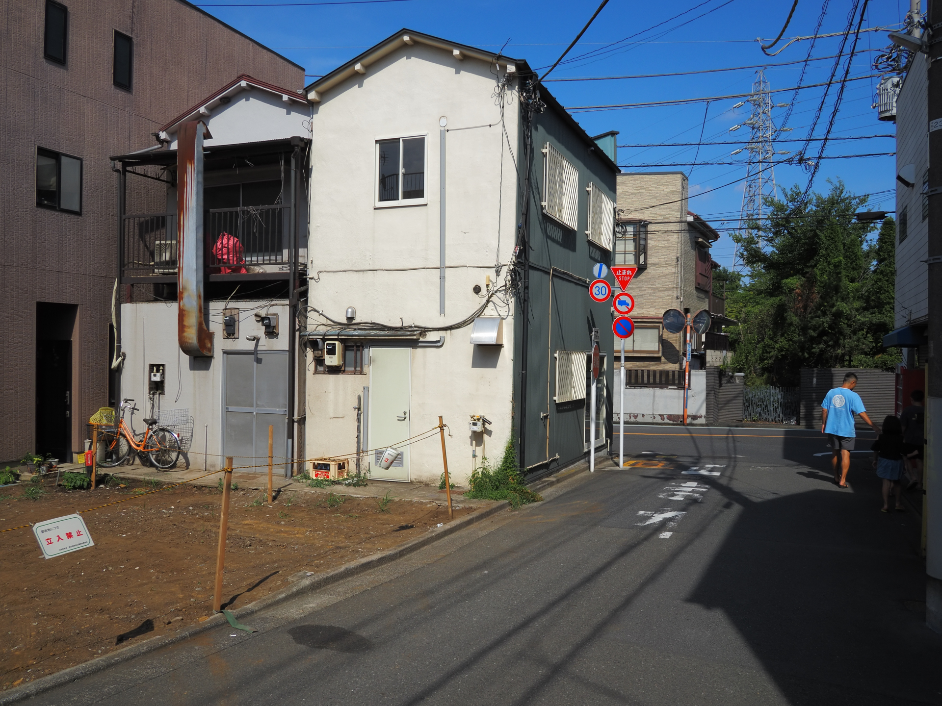 街角。いま、写真集の復刻に伴って、写真家の柳沢信さんのことを研究しています。写真を見すぎると影響を受けやすい単純さです。小型の単焦点レンズを使用して、絞り込んできっちり描写するということが狙いです。満足です。<br><span class="fnt-85">OM SYSTEM OM-5 Mark II／LUMIX G 14mm / F2.5 ASPH.／14mm（28mm相当）／絞り優先AE（1/640秒、F8.0、−0.3EV）／ISO 200</span>