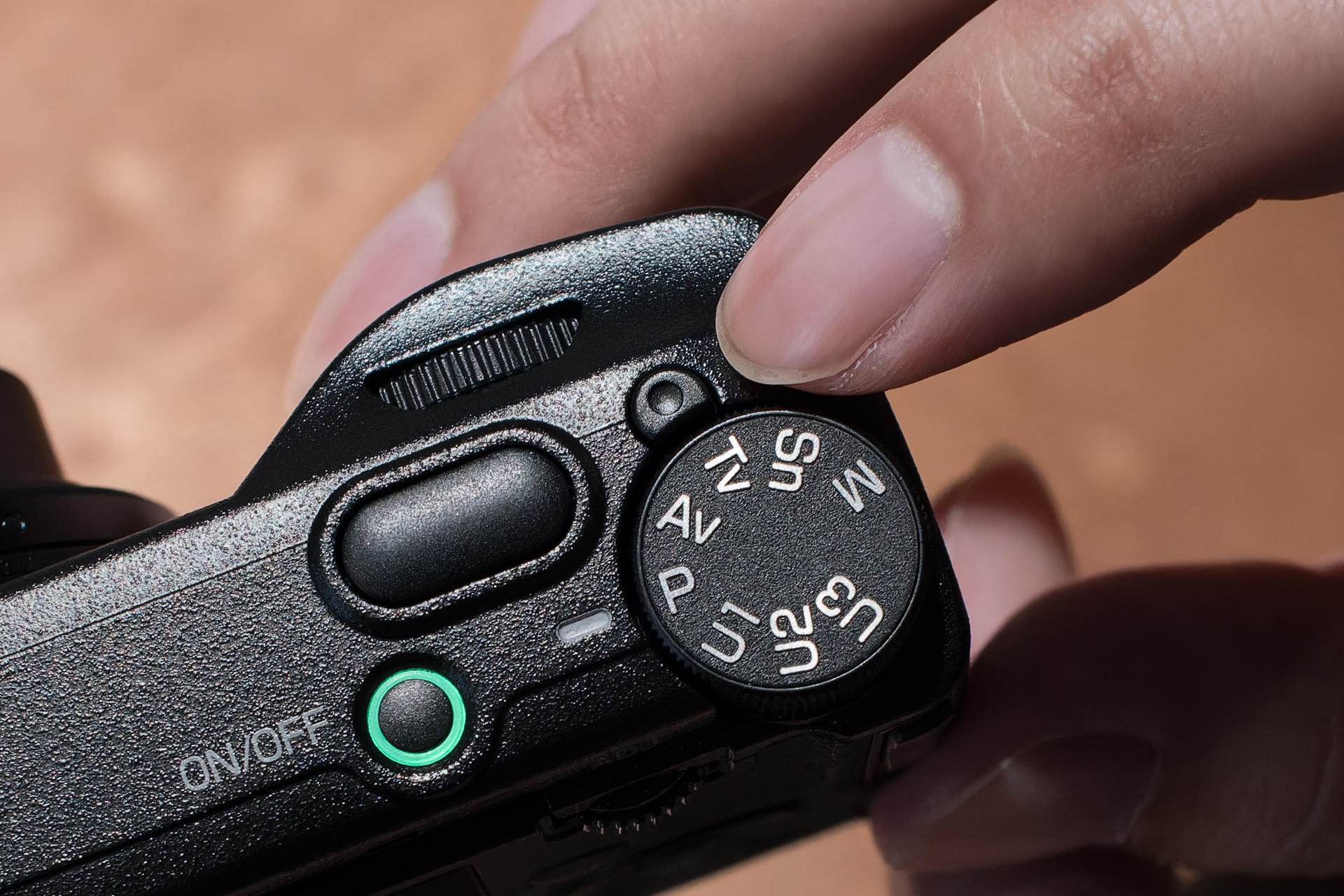 モードダイヤルのロック解除ボタンが、PENTAXでいうグリーンボタンのような役割も兼ねる。押すと、プログラムAEが初期値に戻る。限られたスペースにボタンを追加しようと考え、ロック解除ボタンに目を付けたそうだ