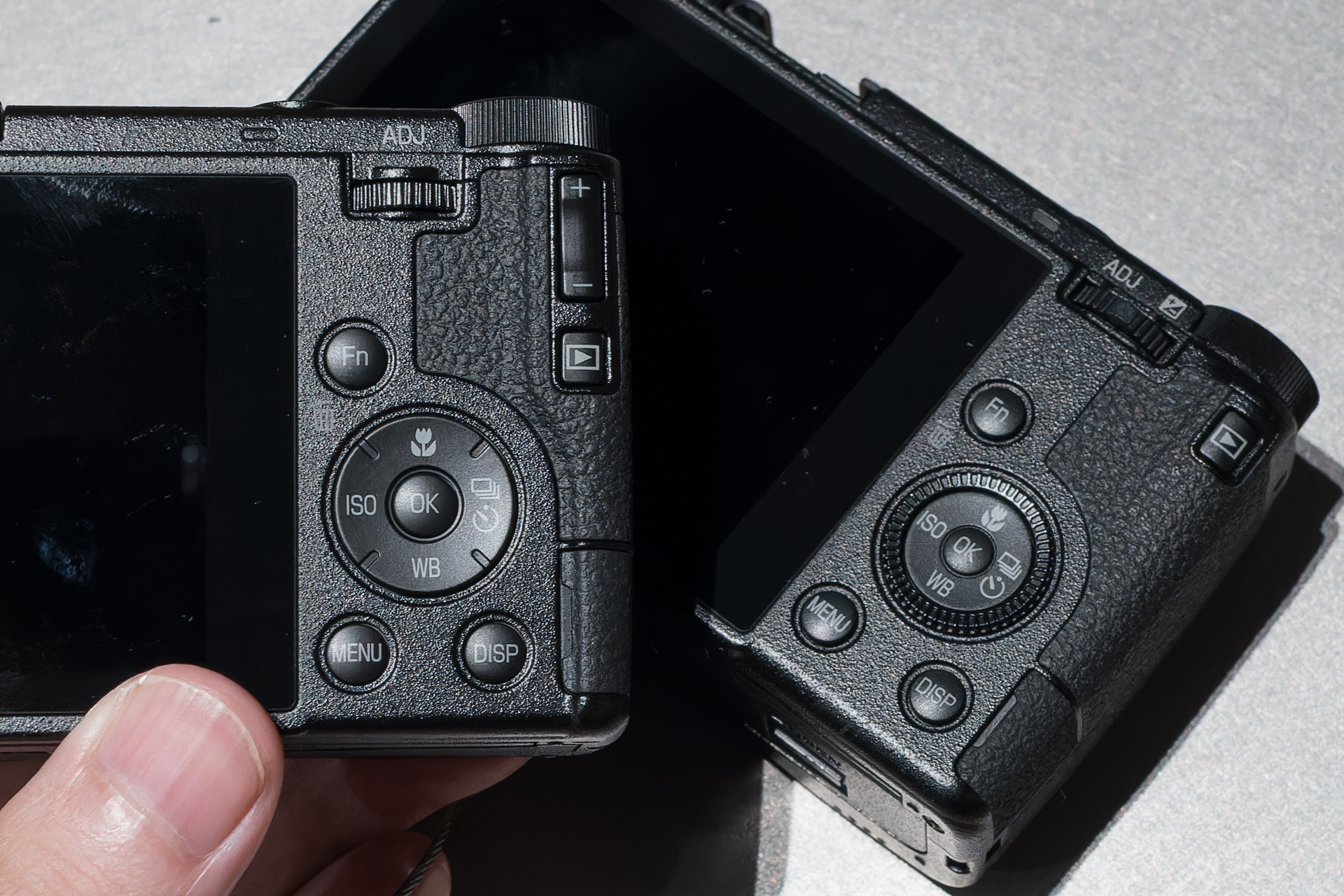 左がGR IV。ADJレバーがダイヤルになり、露出補正ボタンが再び独立。ひとつのレバーで複数の操作をするのが難しいとの声もあったようだ。ホイールがなくなり、十字ボタンの押し心地も確実なものになった